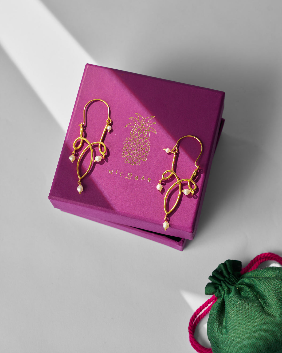 Gold Kolam balis on a purple Nicobar gift box.