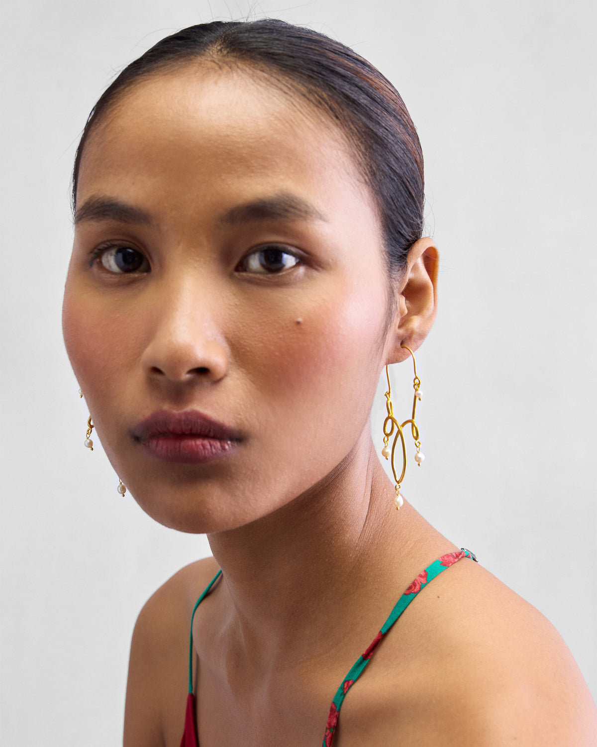 Person wearing gold Kolam balis with pearl drops.
