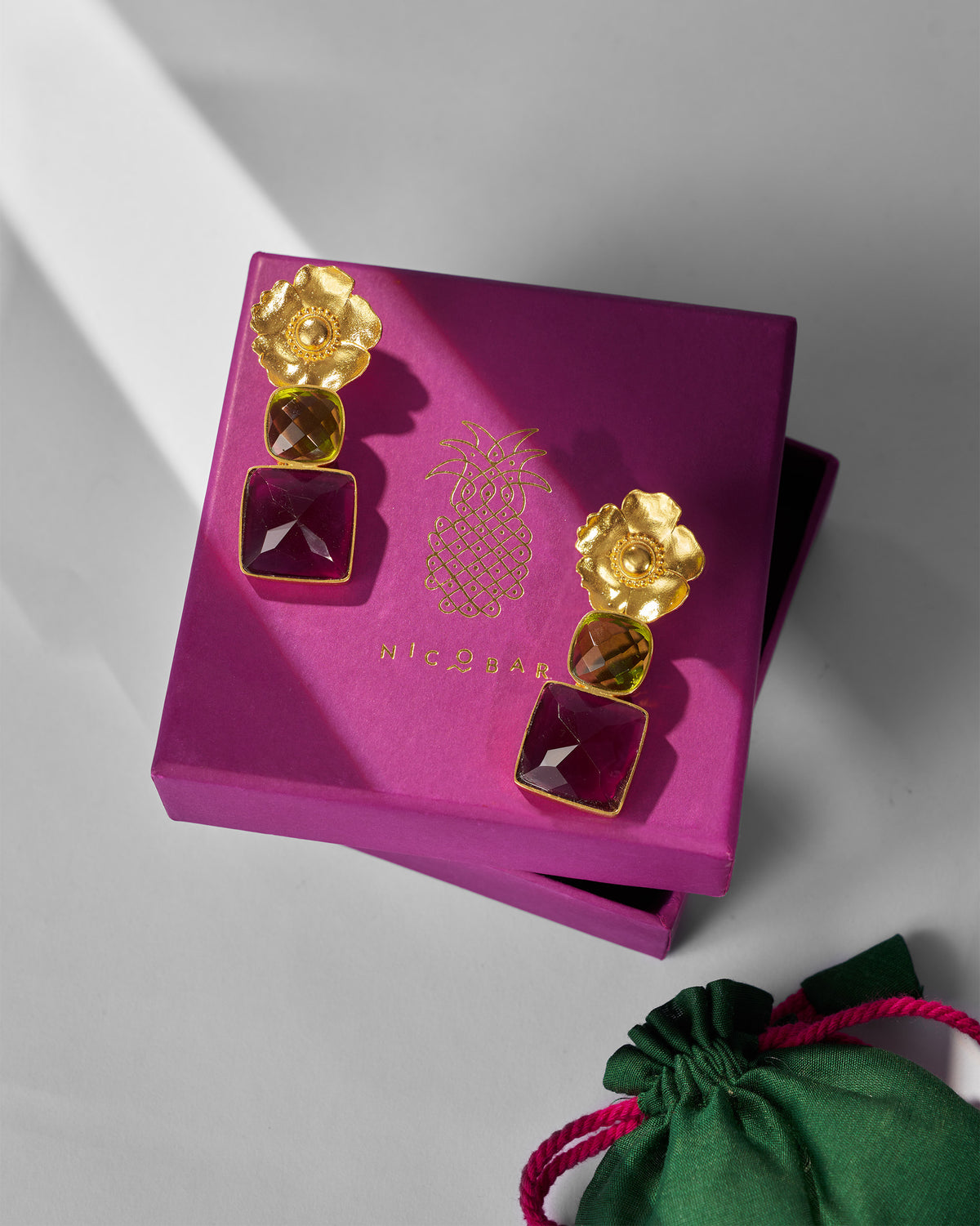 Gold dessert rose drops on a magenta Nicobar gift box.