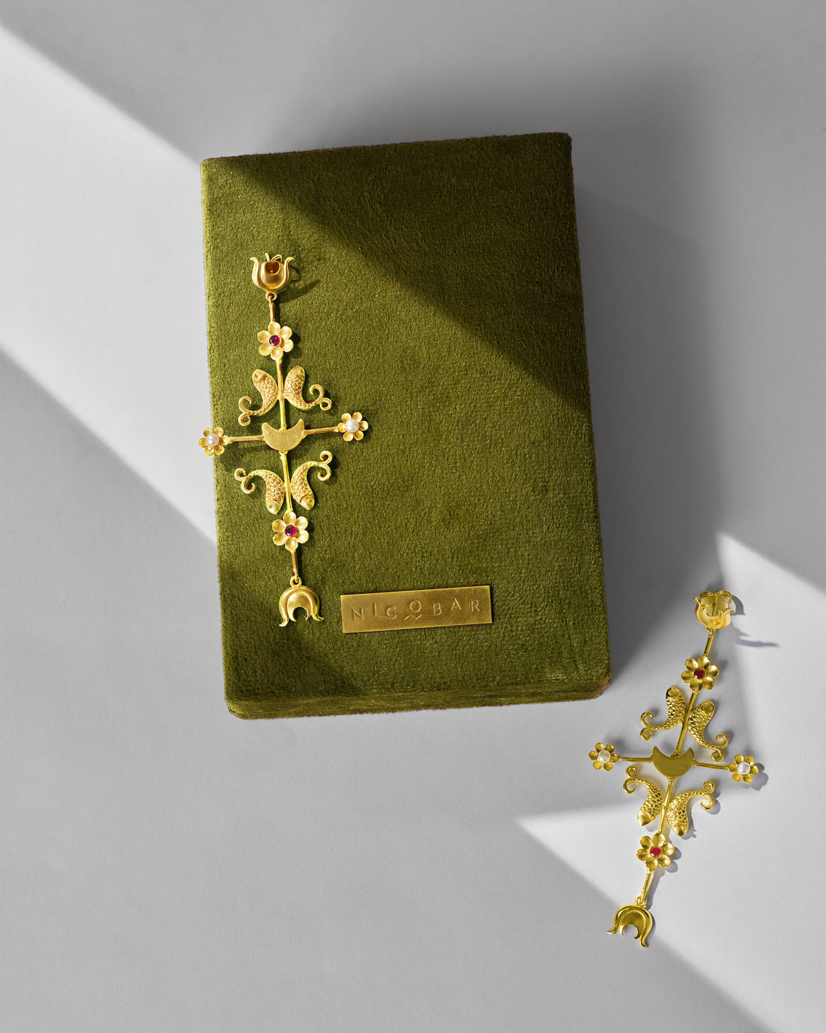 Gold gul baag earrings on an olive Nicobar velvet box.