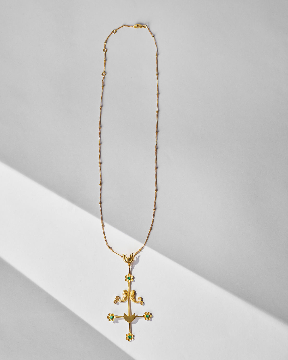 Gold Gul Baag necklace with fish motifs, crescents and green stone flowers.