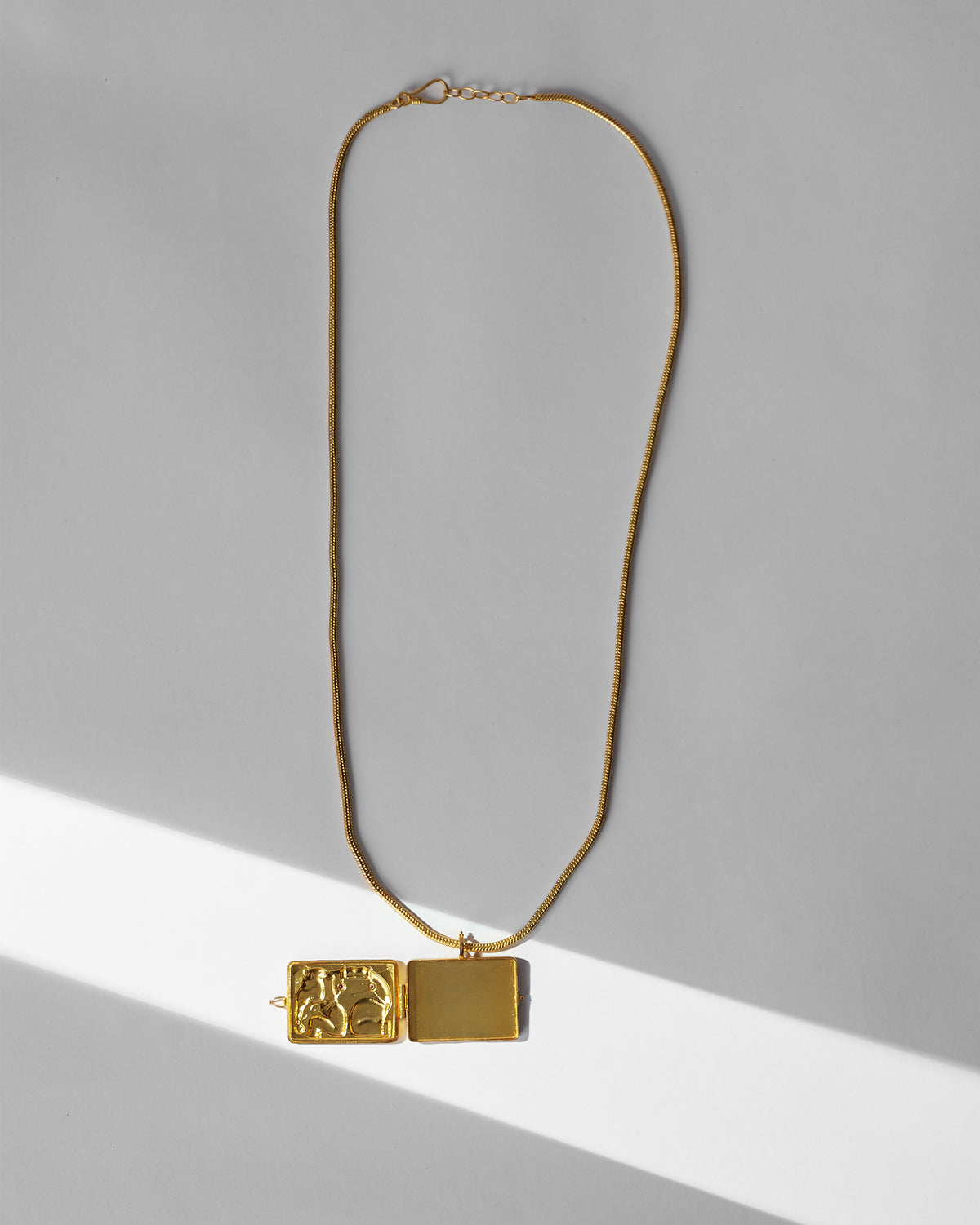 Open gold Appu elephant locket showing the hinged inner compartment.