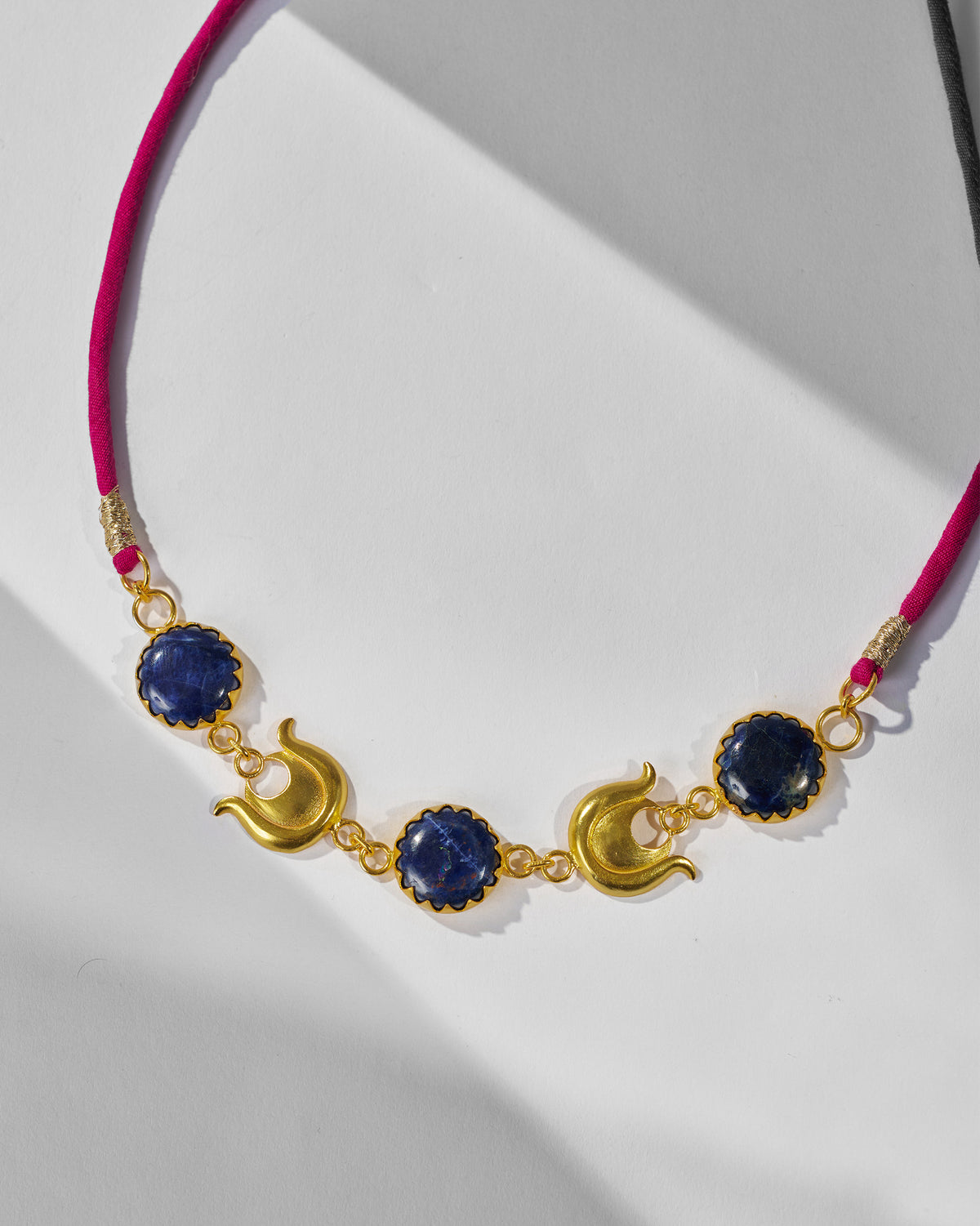 Close-up of gold crescents and blue stones on the Chandphool Choker.