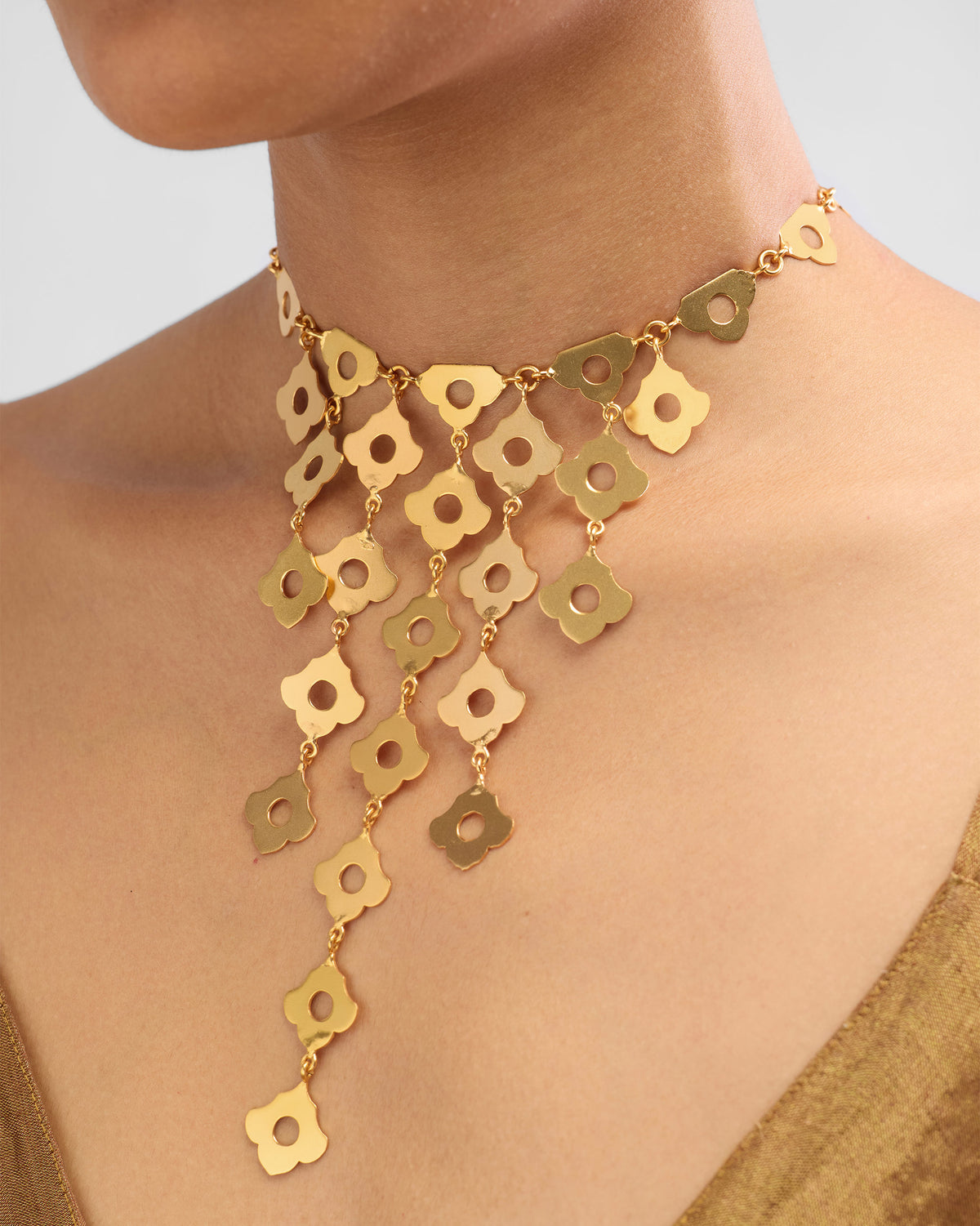 Close-up of a gold Phool Jaal bib necklace of linked flower charms.