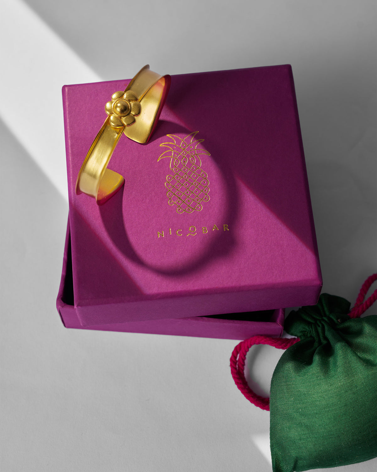 Clover Cuff displayed on a magenta gift box.