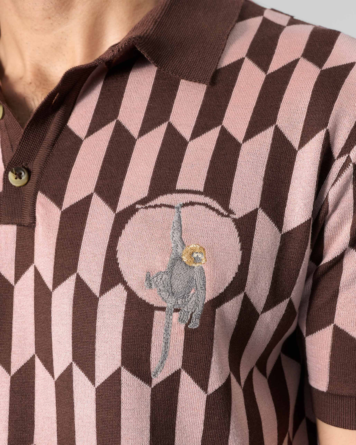 Close-up of a langur embroidery on a brown-and-pink Langur polo.