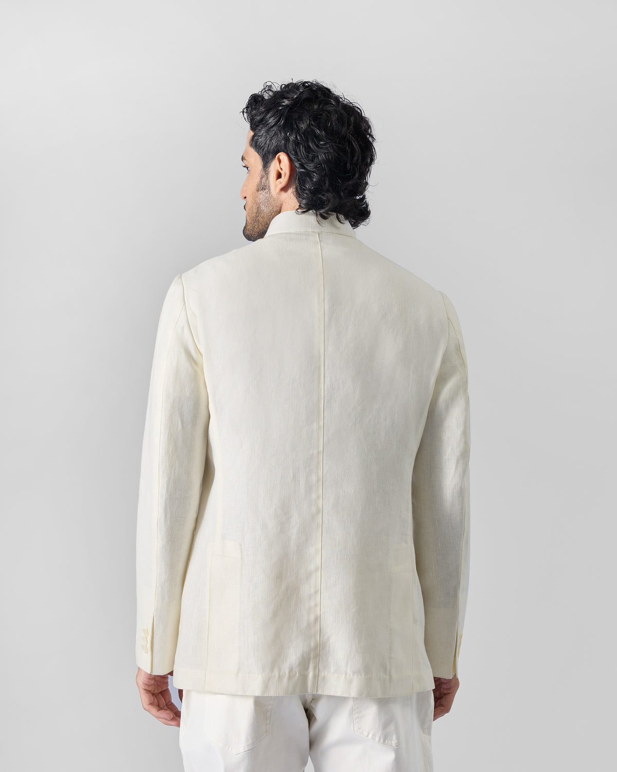 Back of an ivory Tahr Bandhgala jacket worn by a person.
