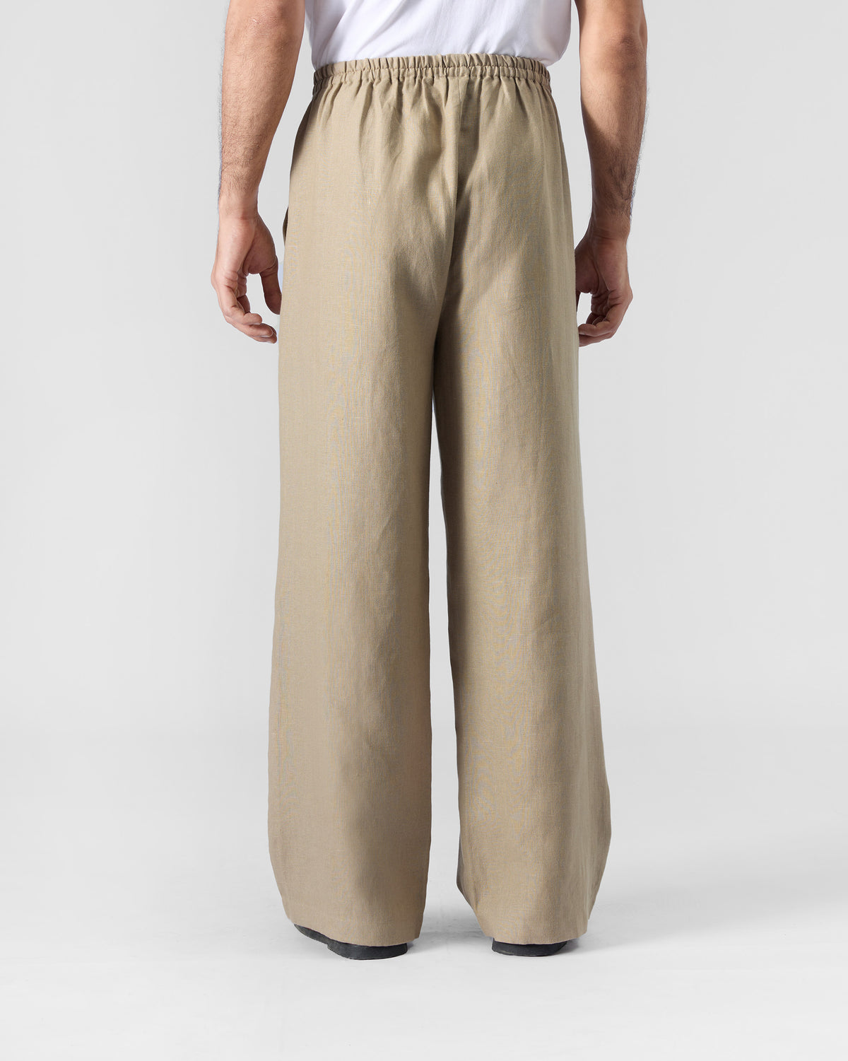 Back of sand Ibex trousers with an elastic waistband and wide legs.