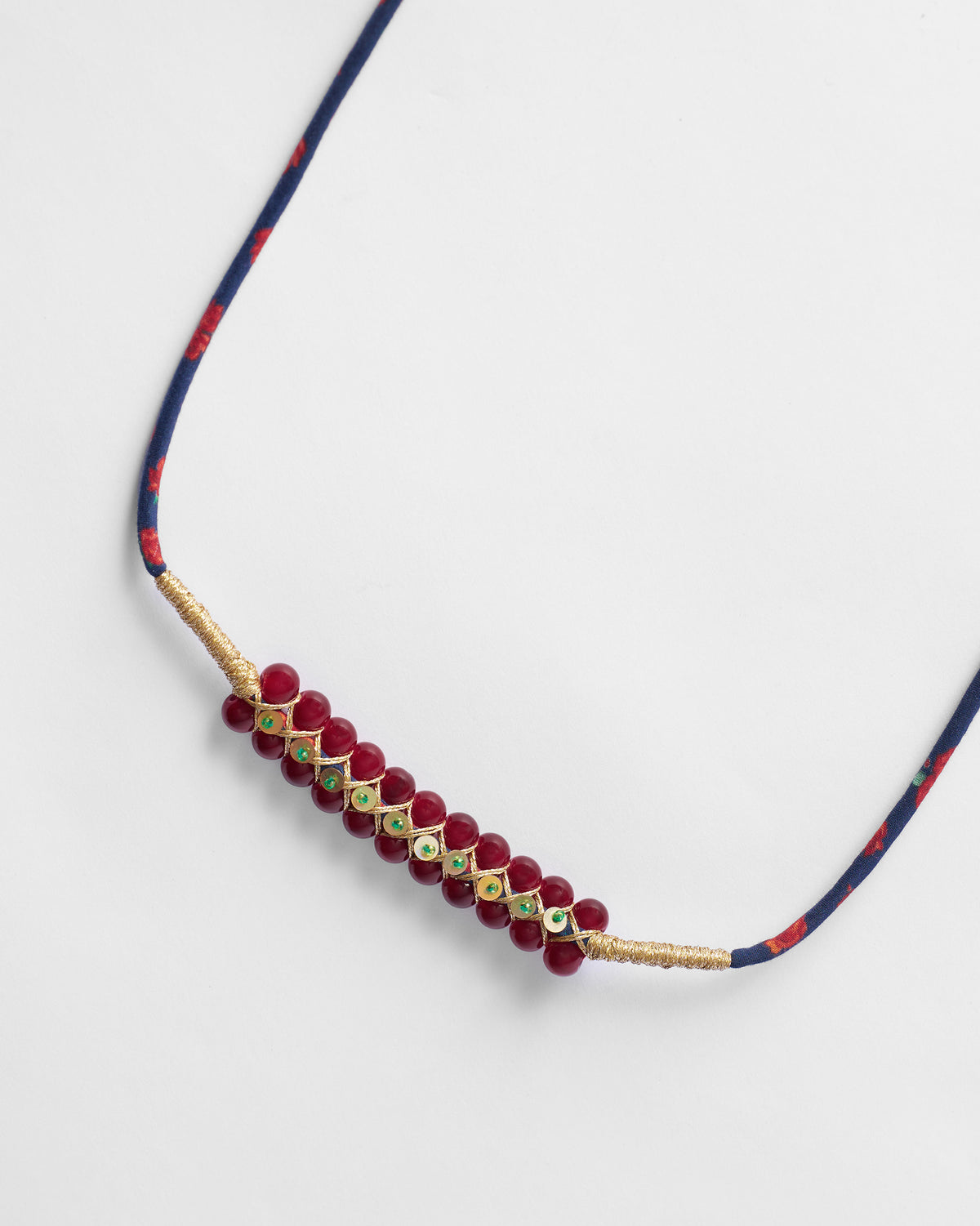 Close-up of the red beaded strap detail on a Muris Sling.