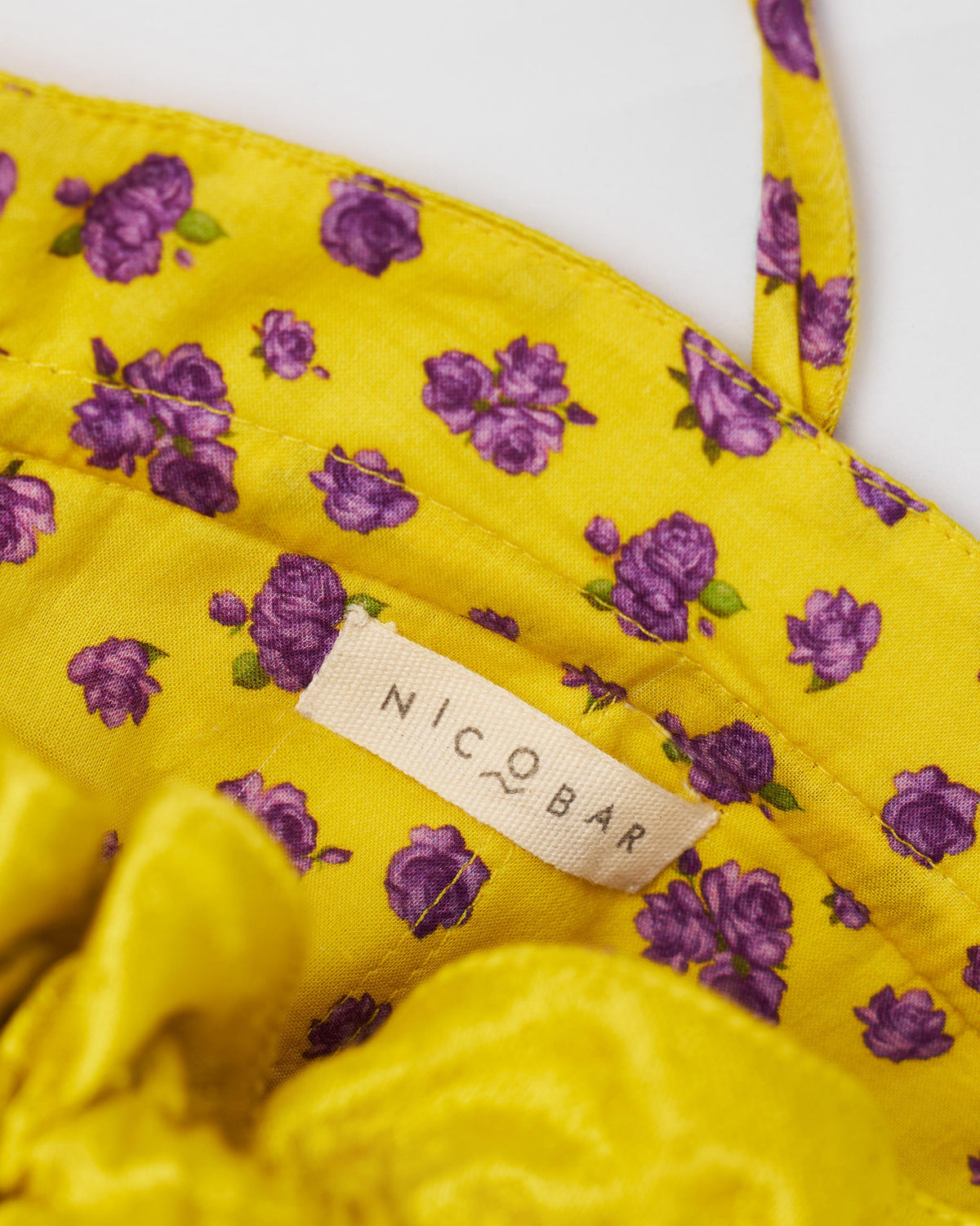 Close-up of the Firefly Potli interior with a purple floral lining and Nicobar label.