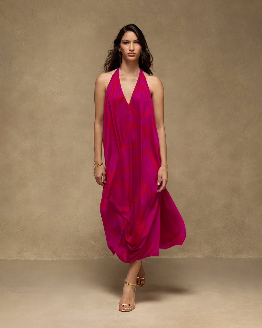 The Shaker Halter Dress, front view: a pink modal satin halter dress with an orange wave print and an A-line shape.