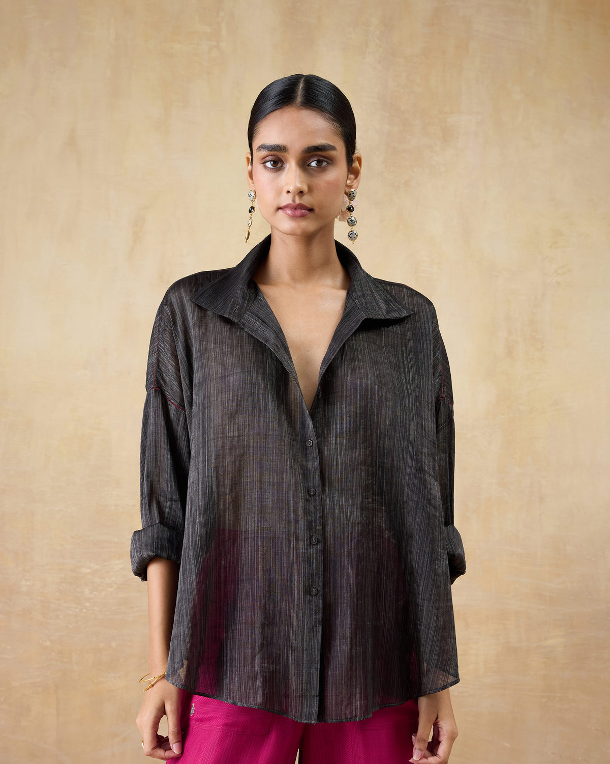 Person wearing a black Firefly shirt with a point collar and loose sheer drape.