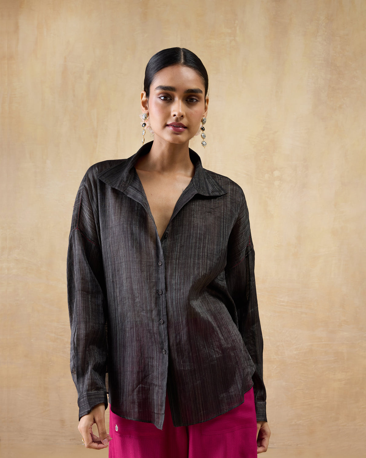 Person wearing a black Firefly shirt with a pointed collar and button placket.