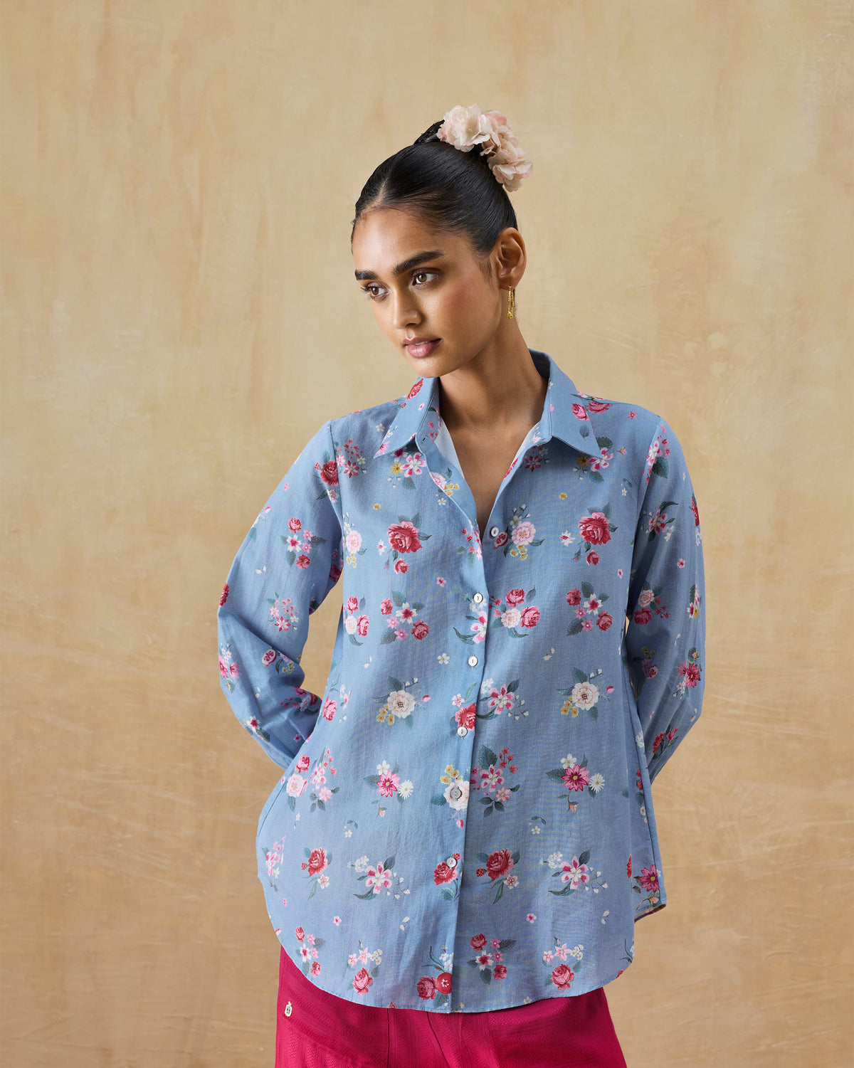 Person wearing an ice blue Detour shirt with a Guldasta floral print.