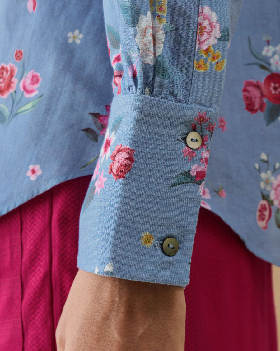 Close-up of the buttoned cuff of the Detour Shirt, showing the Guldasta rose print on ice blue cotton linen.