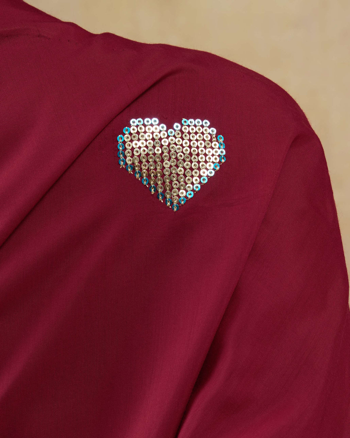 Close-up of a sequinned heart motif on a red Tokyo off-shoulder top.