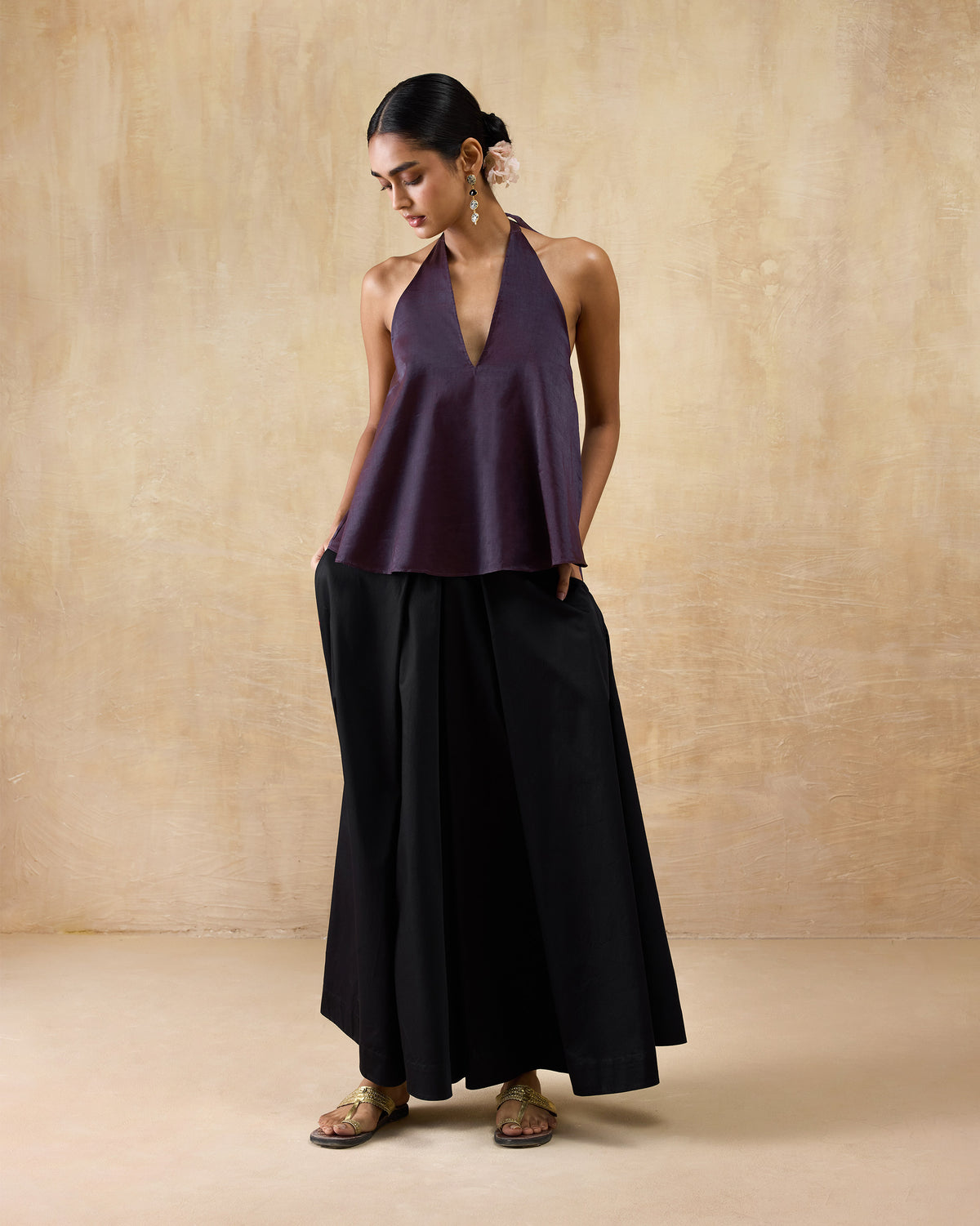 Person wearing a plum metallic A-line halter top.