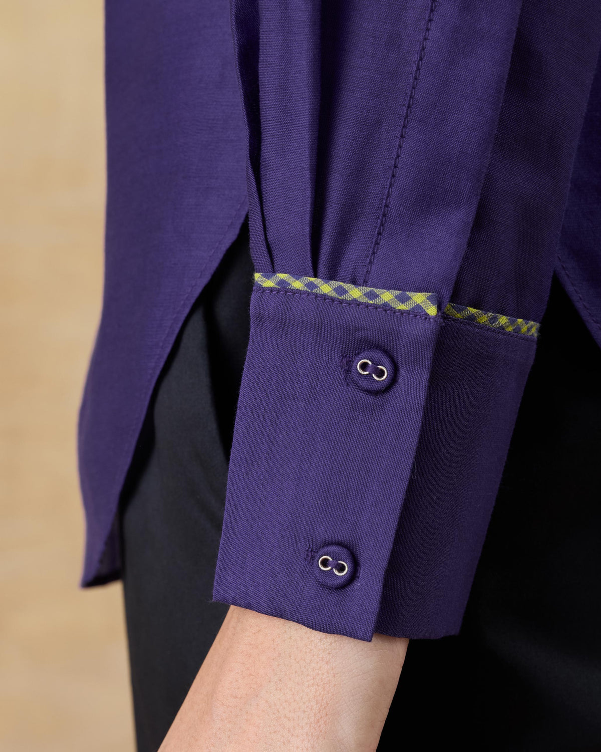Close-up of fabric-covered cuff buttons and check piping on a purple Tuxedo Shirt.
