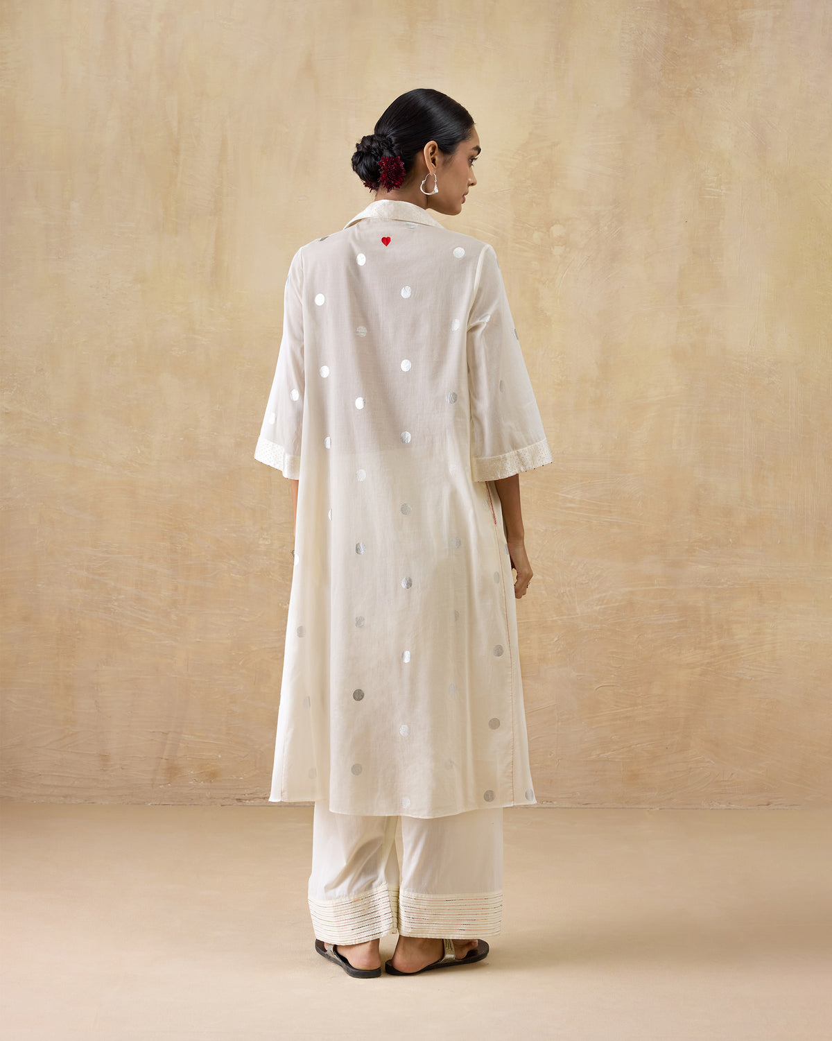 Back of an ivory Rejoice kurta with silver dots and a red heart.
