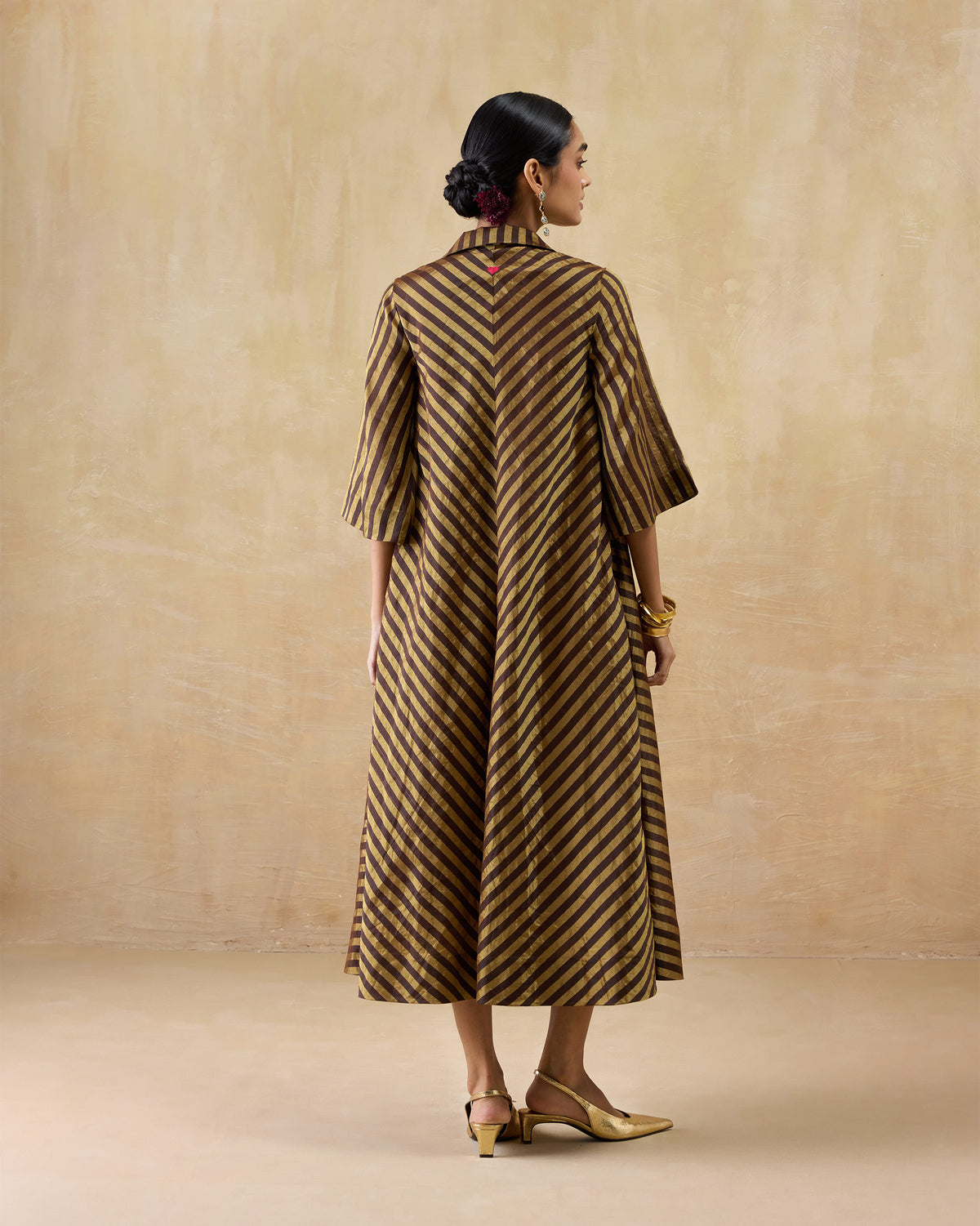 Back of a chocolate and gold striped Areva Dress with a chevron seam.