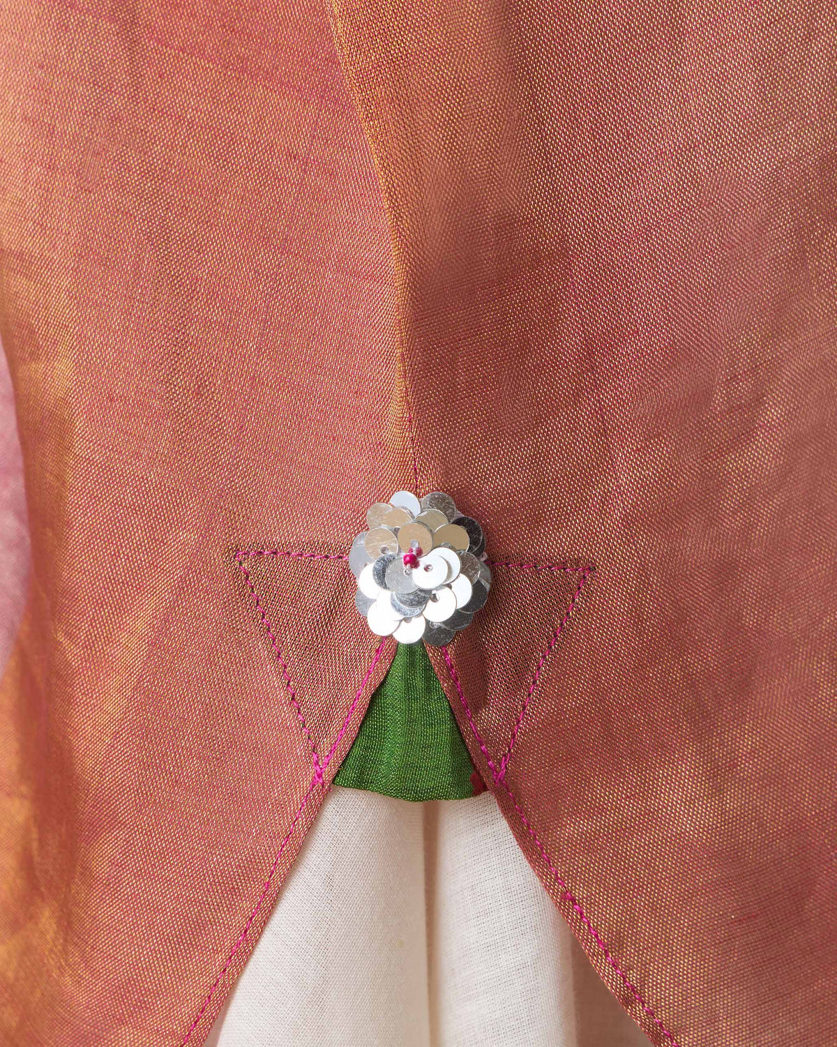 Close-up of a sequin flower and green inset at a pink Jhilmil Kaftan slit.