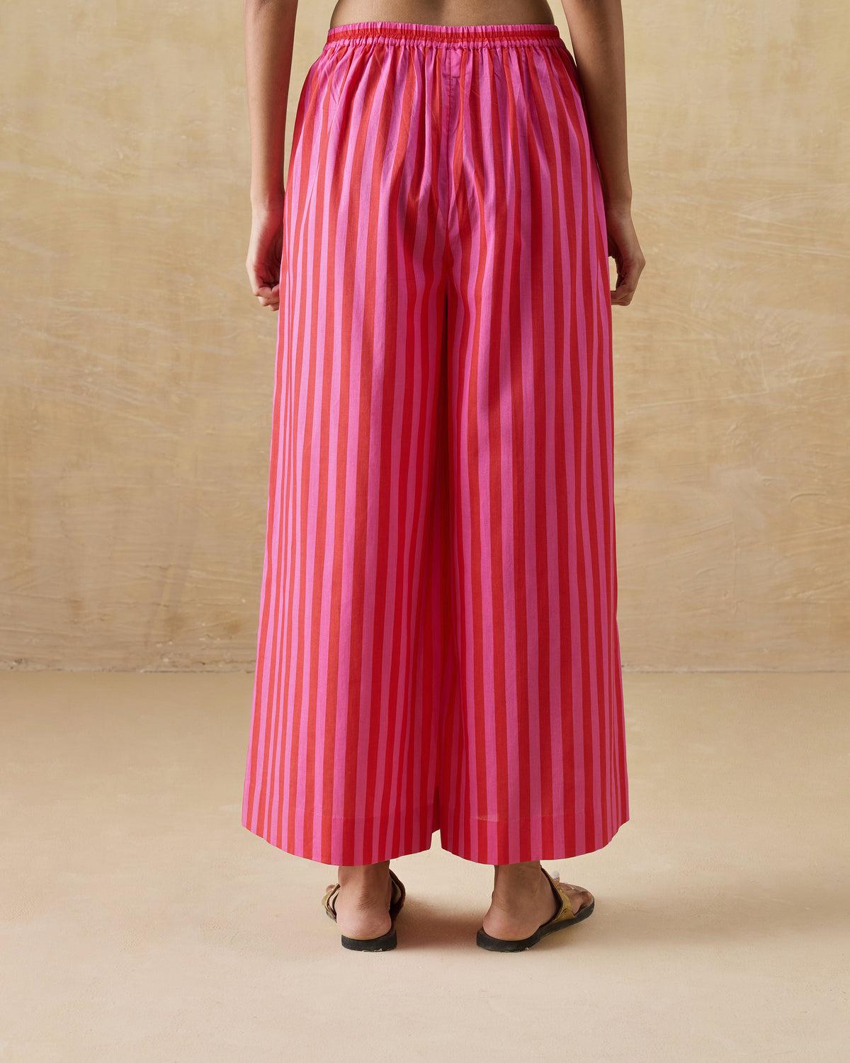 Back of red and berry striped Basic pyjamas with an elastic waist.