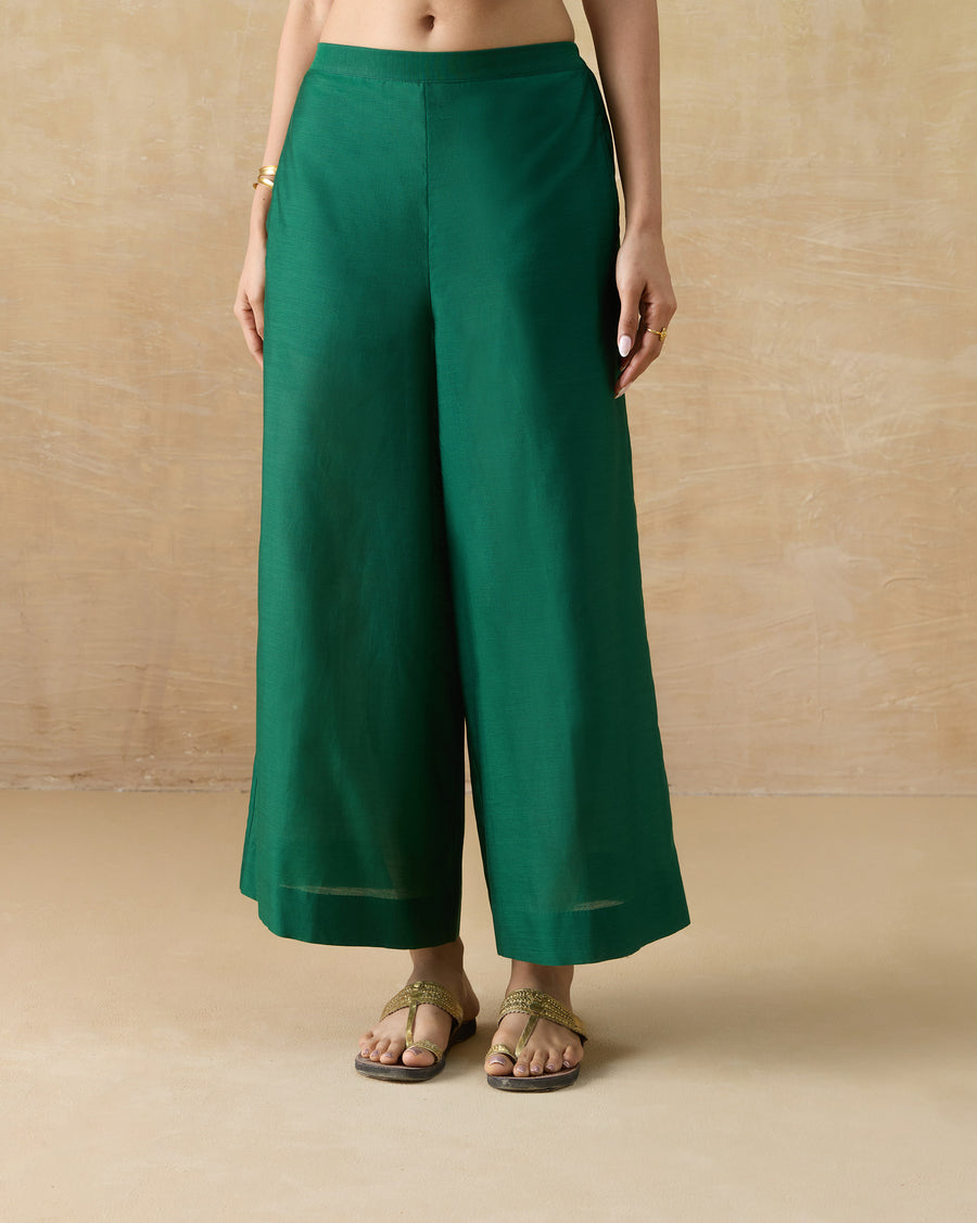The Basic Pyjamas, wide A-line emerald green cotton silk pyjamas, worn with flat sandals.