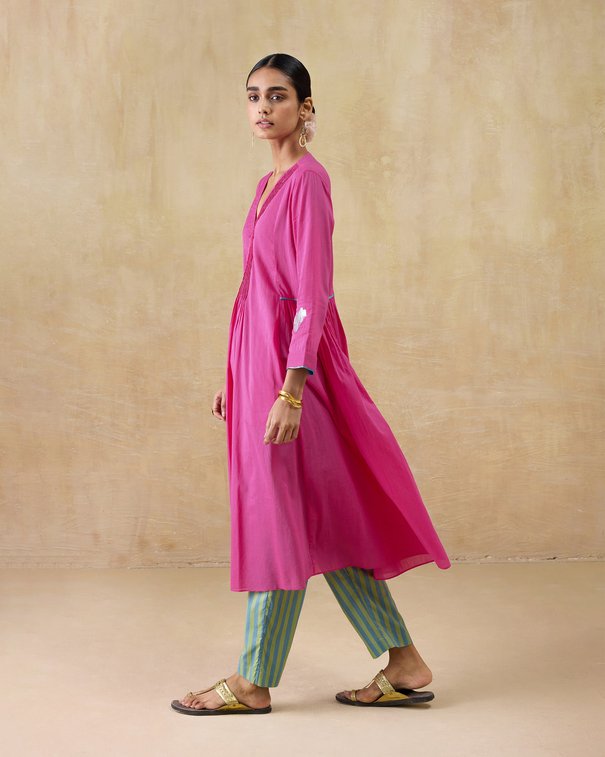 Side view of a bright pink Pintuck kurta with a flared skirt.