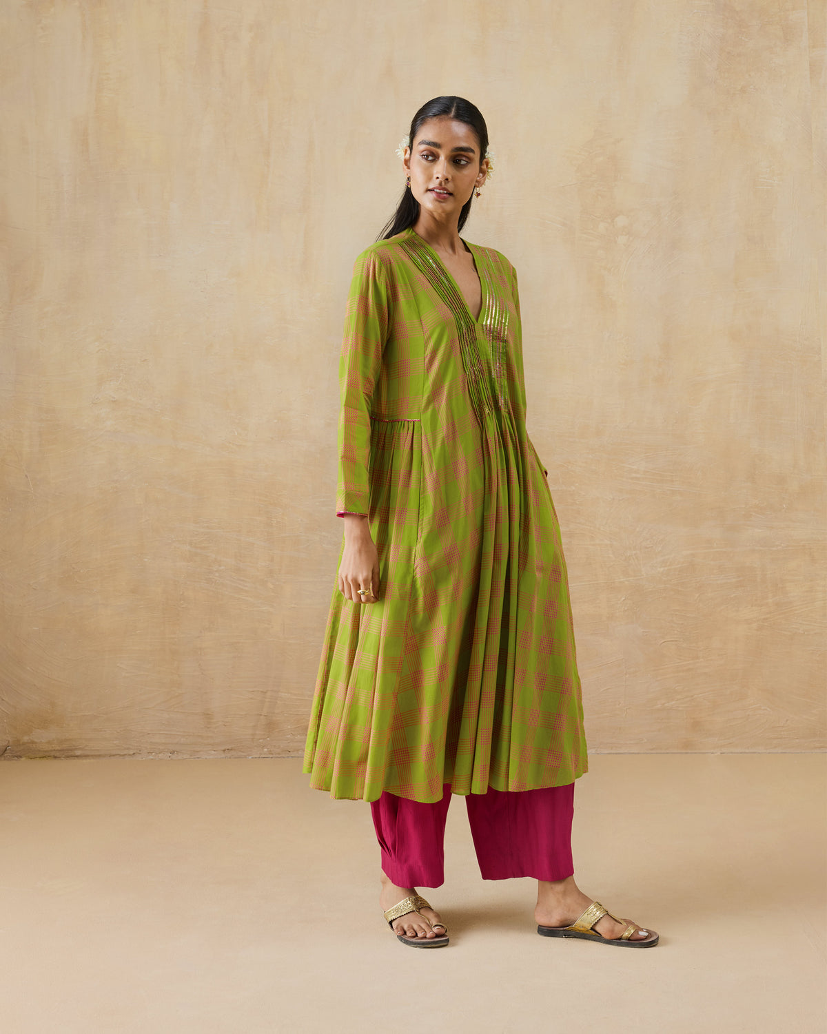 Person wearing a lime green Pintuck kurta with pink checks and a gold sequin V-neck.