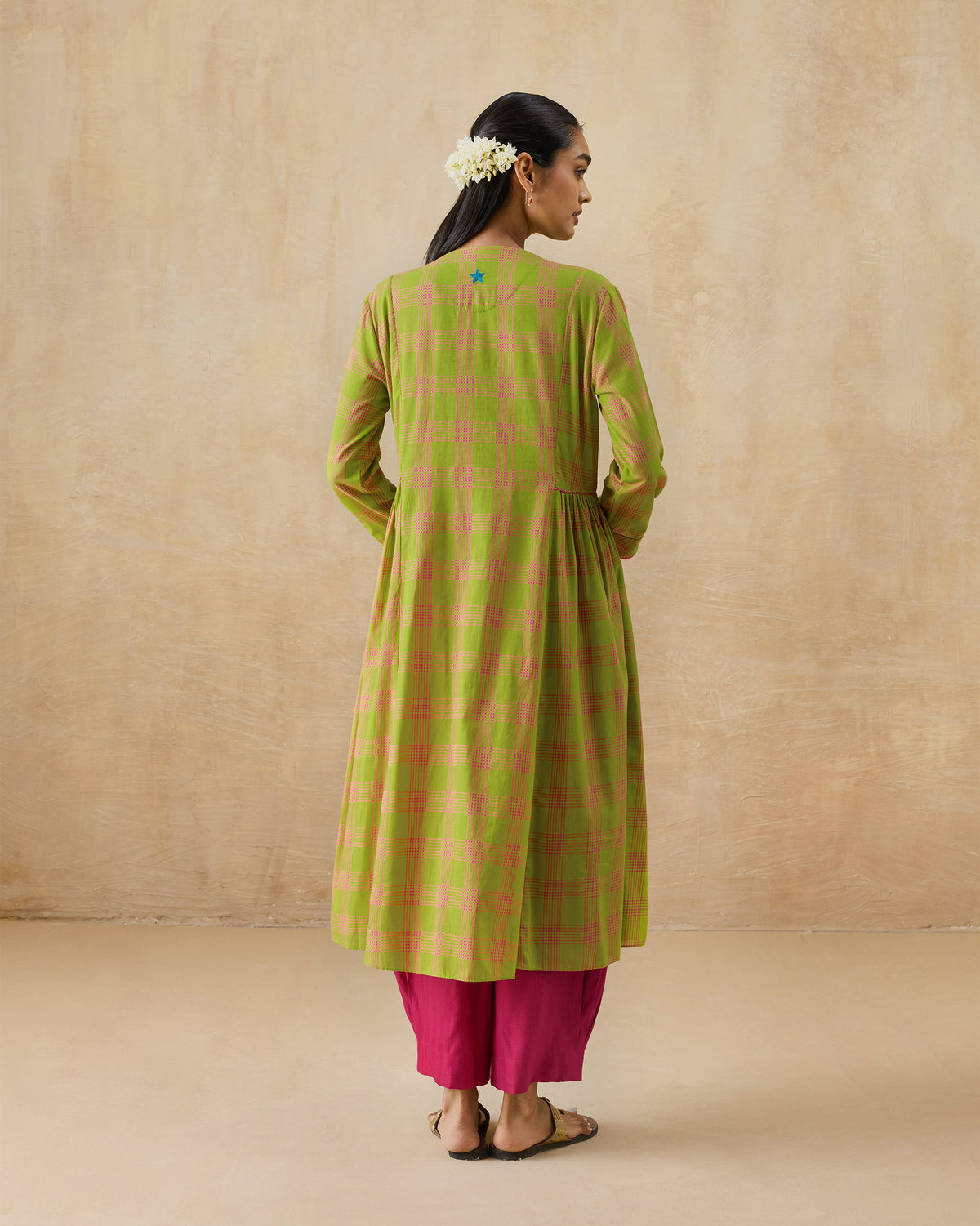 Back of a lime green Pintuck kurta with a blue embroidered star.