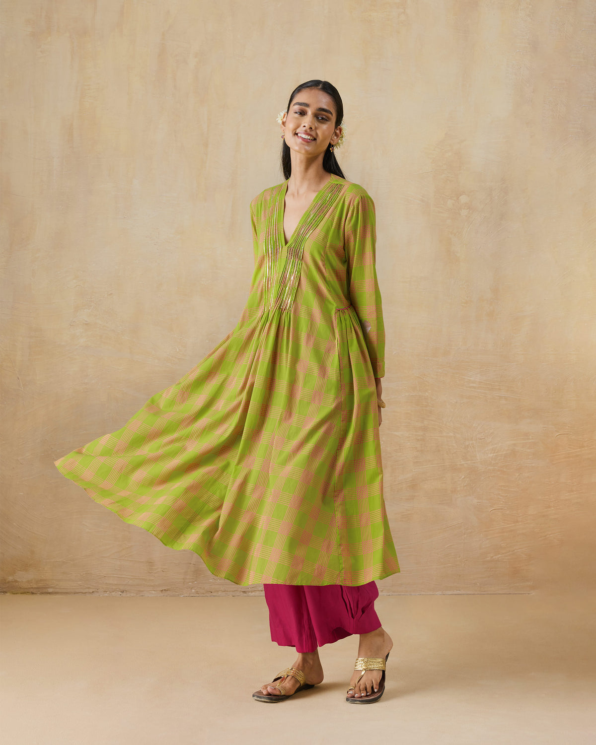Front of a lime green Pintuck kurta with a flared skirt and gold sequin neckline.
