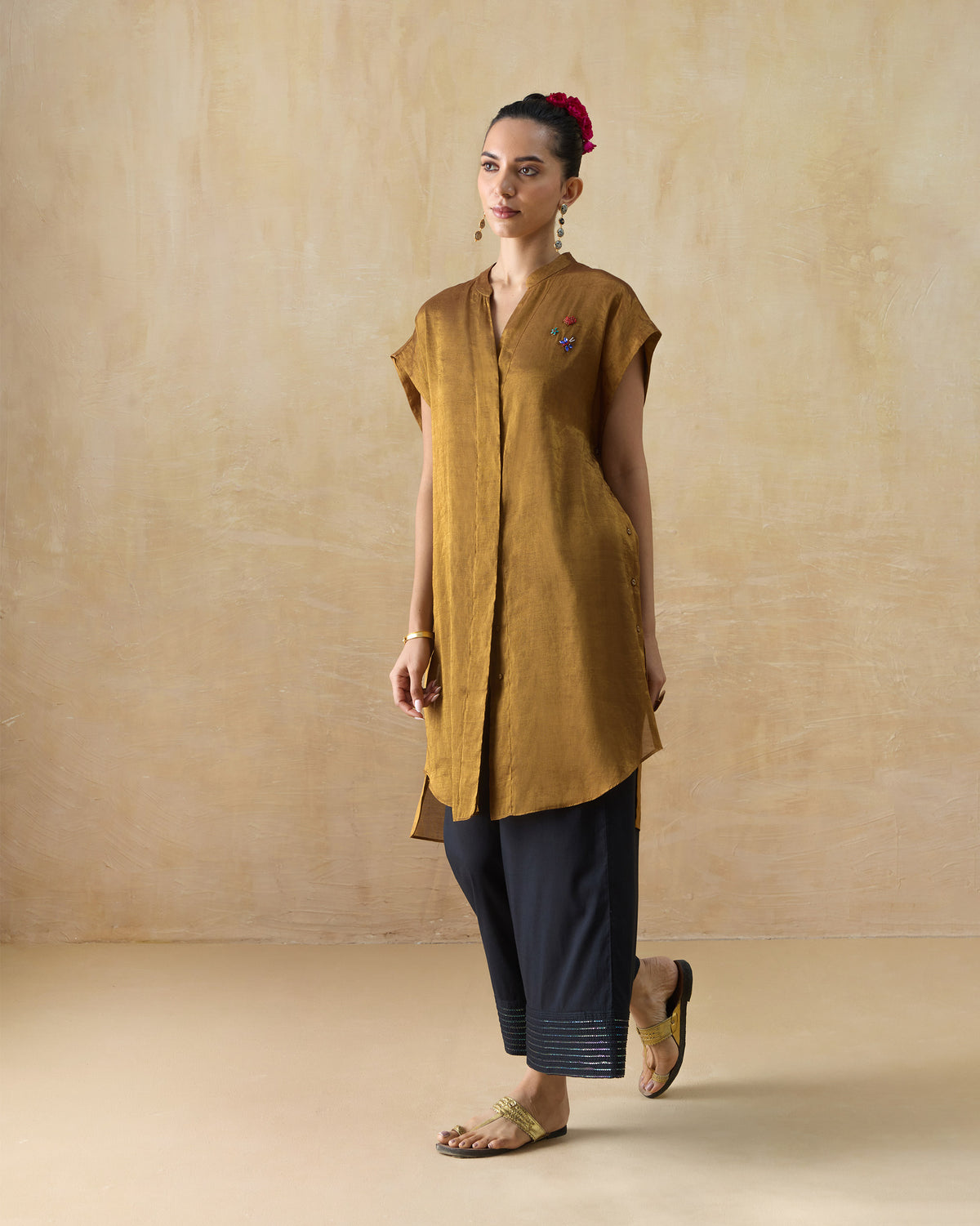 Person wearing a long gold metallic Tango kaftan with cap sleeves.