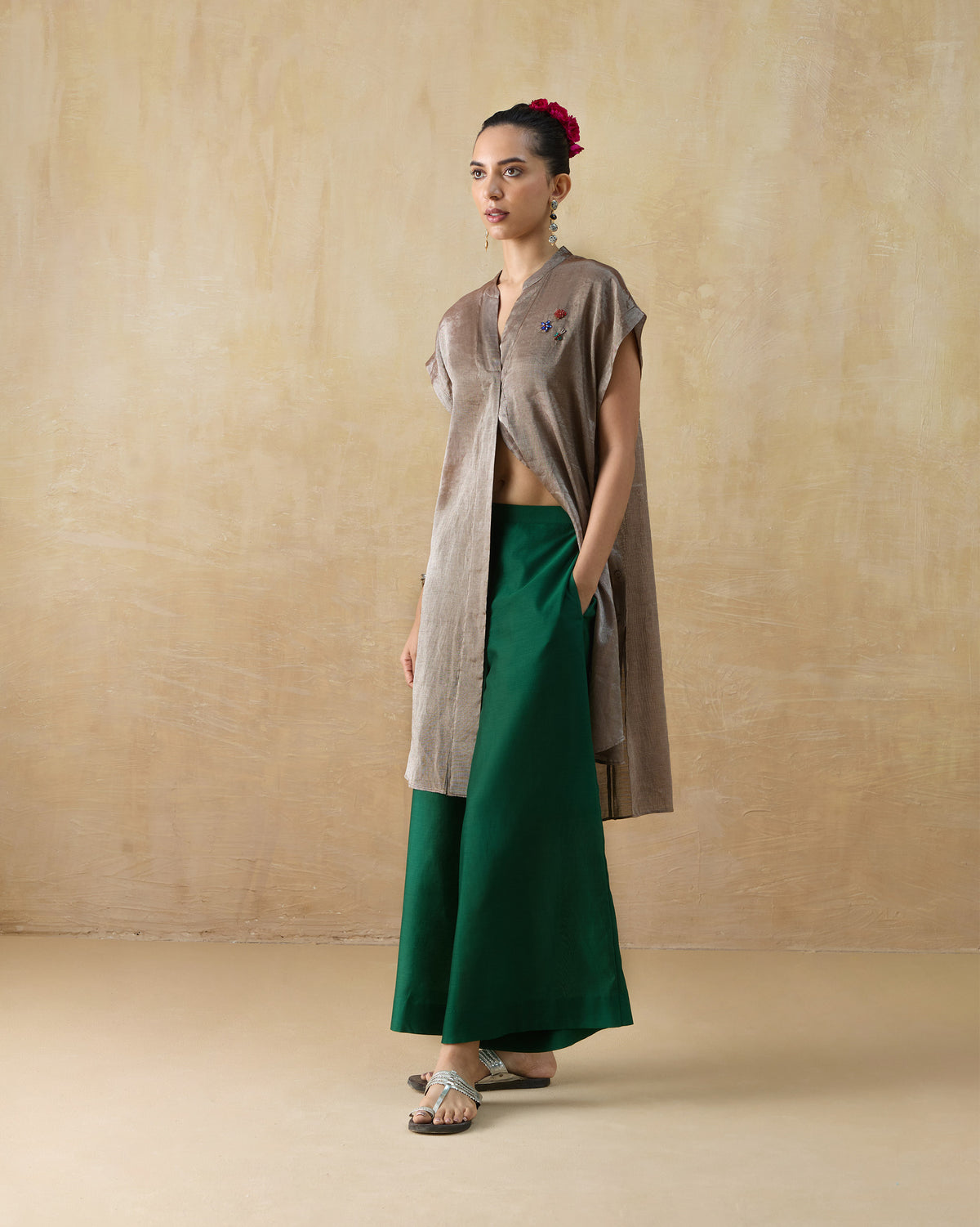 Person wearing a silver metallic kaftan with a front slit and shoulder embroidery.