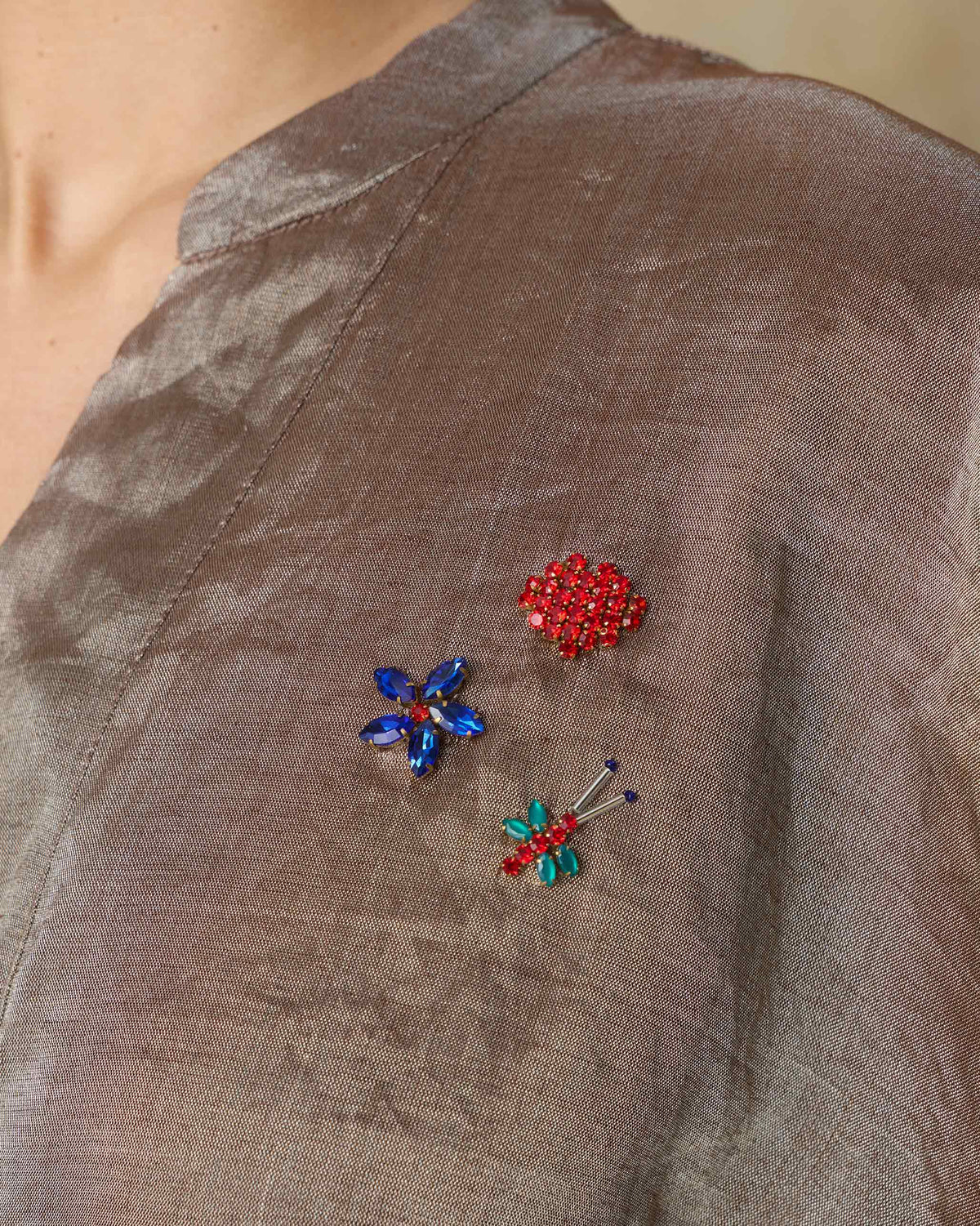 Close-up of a silver metallic kaftan with stone-embroidered shoulder motifs.