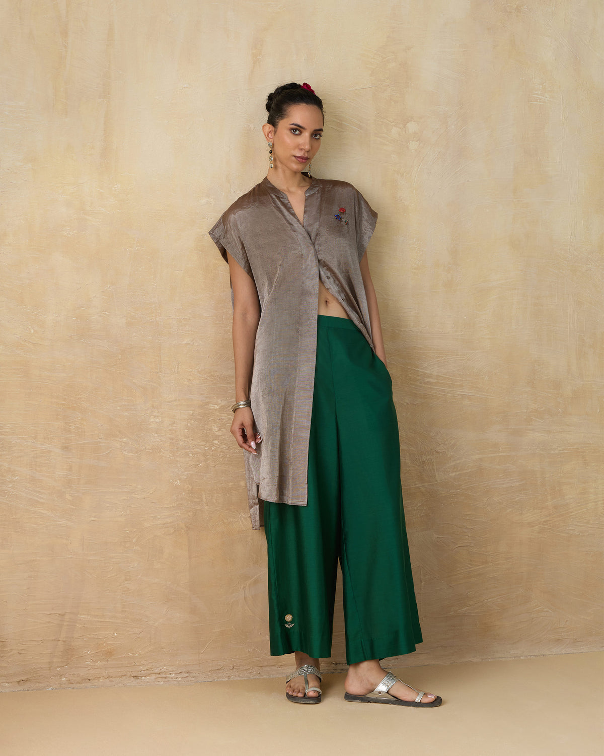 Person wearing a long silver metallic kaftan with a front slit.