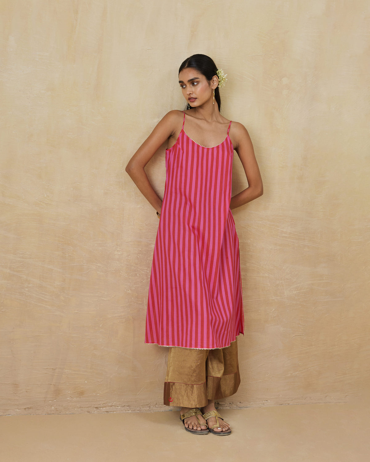 Person wearing a red and berry striped Mist Camisole with a scalloped hem.