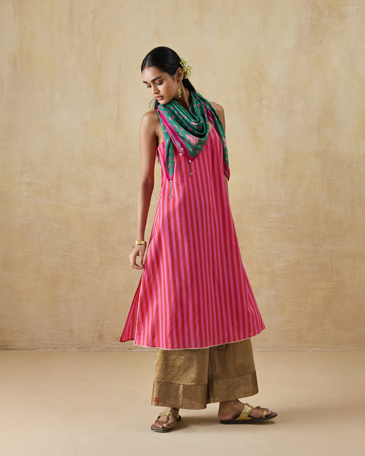 Person wearing a red and berry striped Mist Camisole with a green scarf.