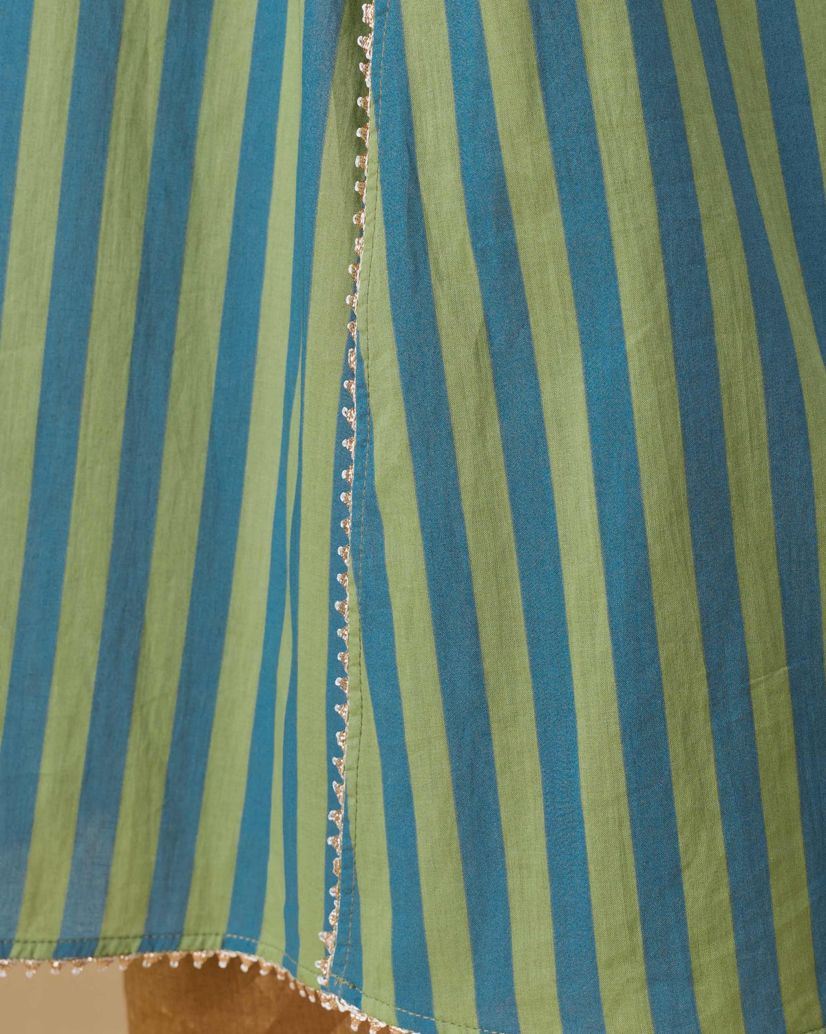 Close-up of lace trim on a green and blue striped Mist camisole.