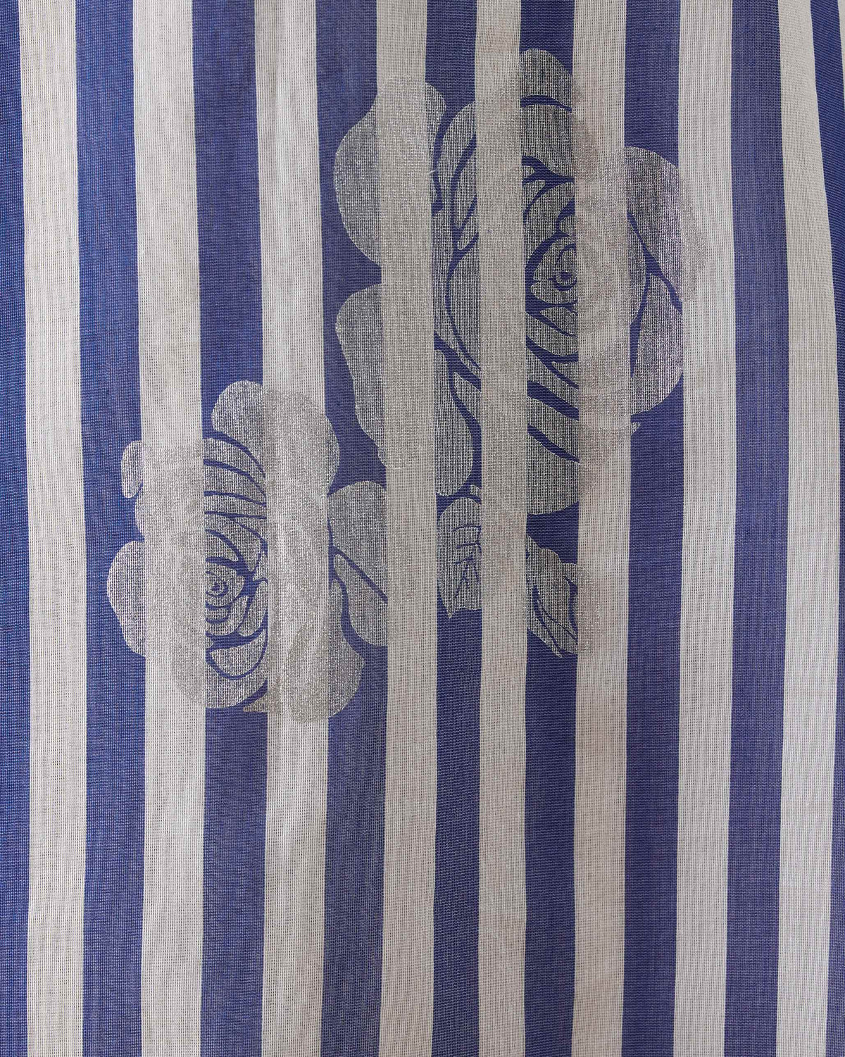 Close-up of silver foil roses on a cobalt and ivory striped boat-neck kurta.