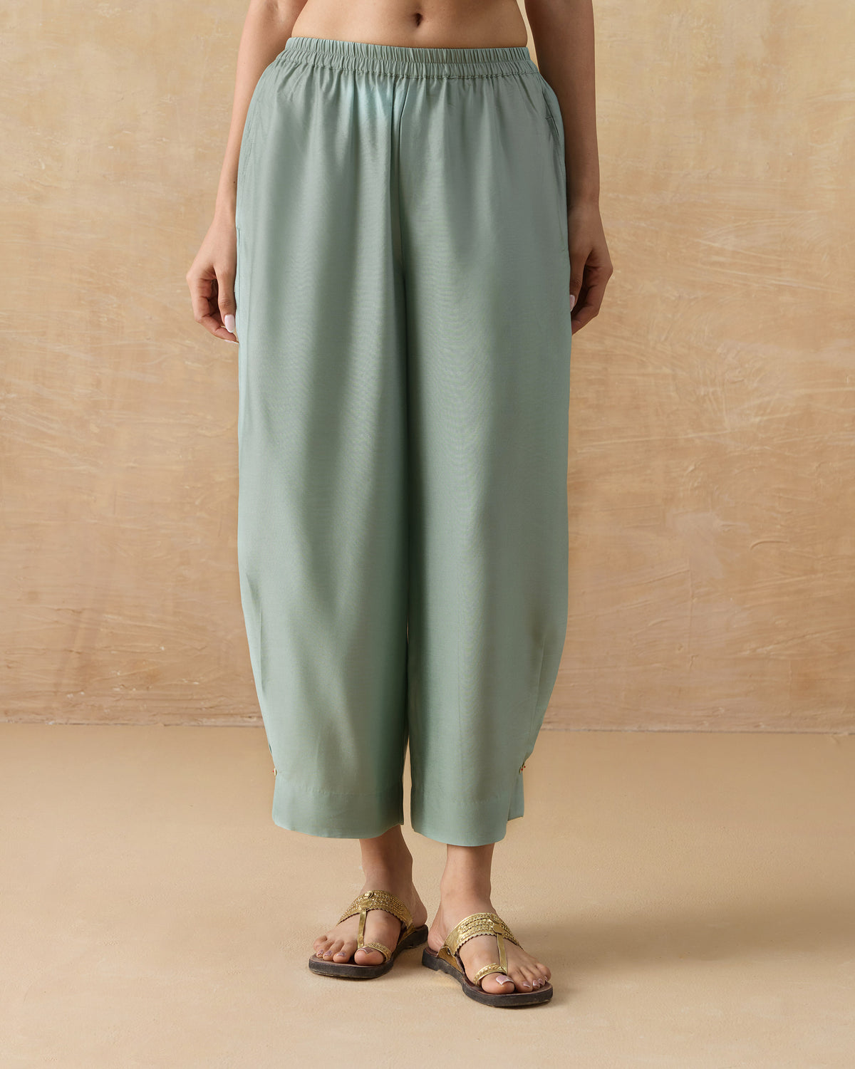Person wearing pale green Wander Pants with an elastic waistband.
