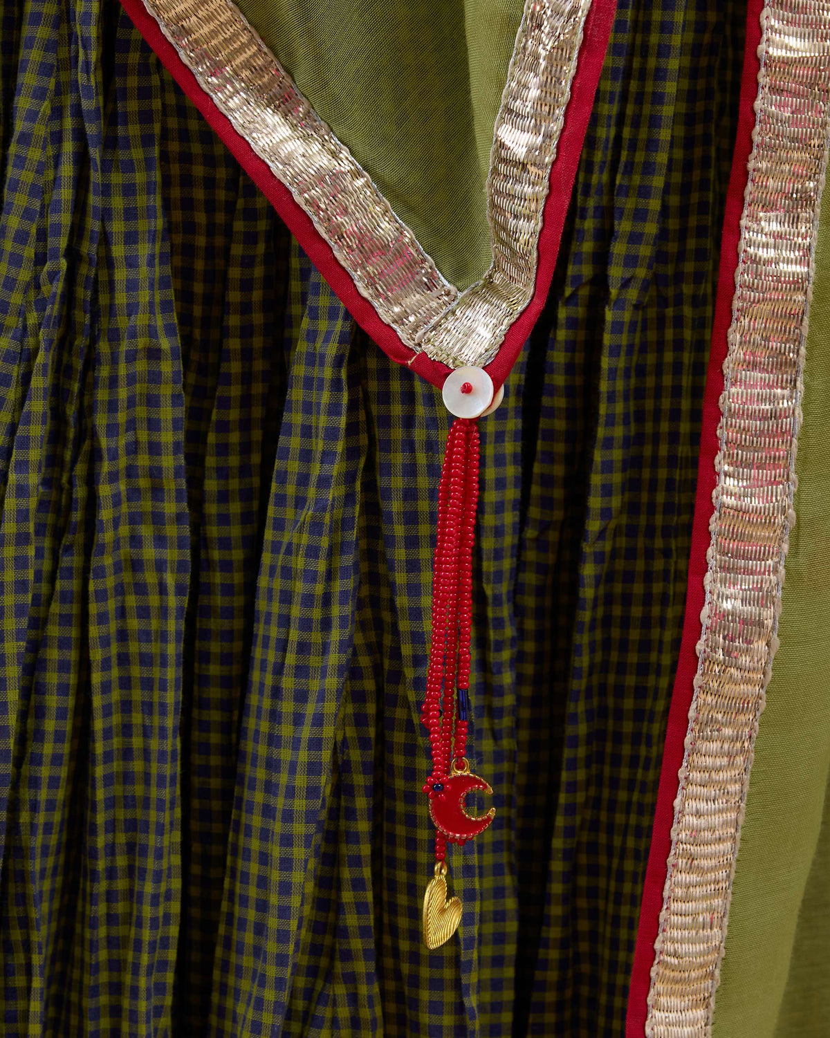 Close-up of Cauvery Dupatta with a gold border and red tassel.