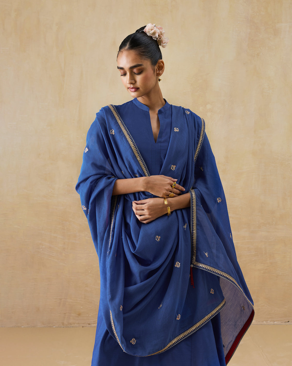 Person wearing a blue Leher dupatta with a gold embroidered border.