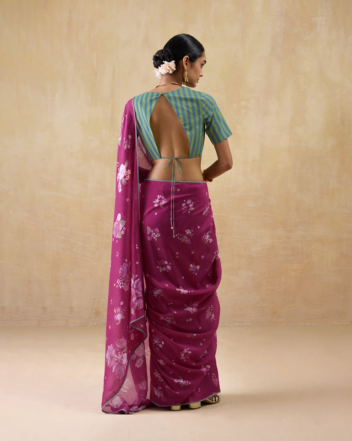 Back of a berry Speckle sari with a floral pallu hanging down.