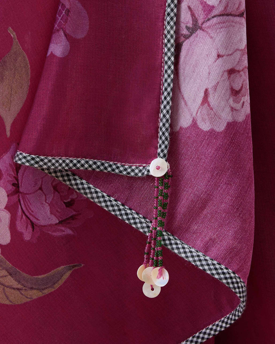 Close-up of a corner of the Speckle Sari: black and white gingham binding and a tassel with shell discs.