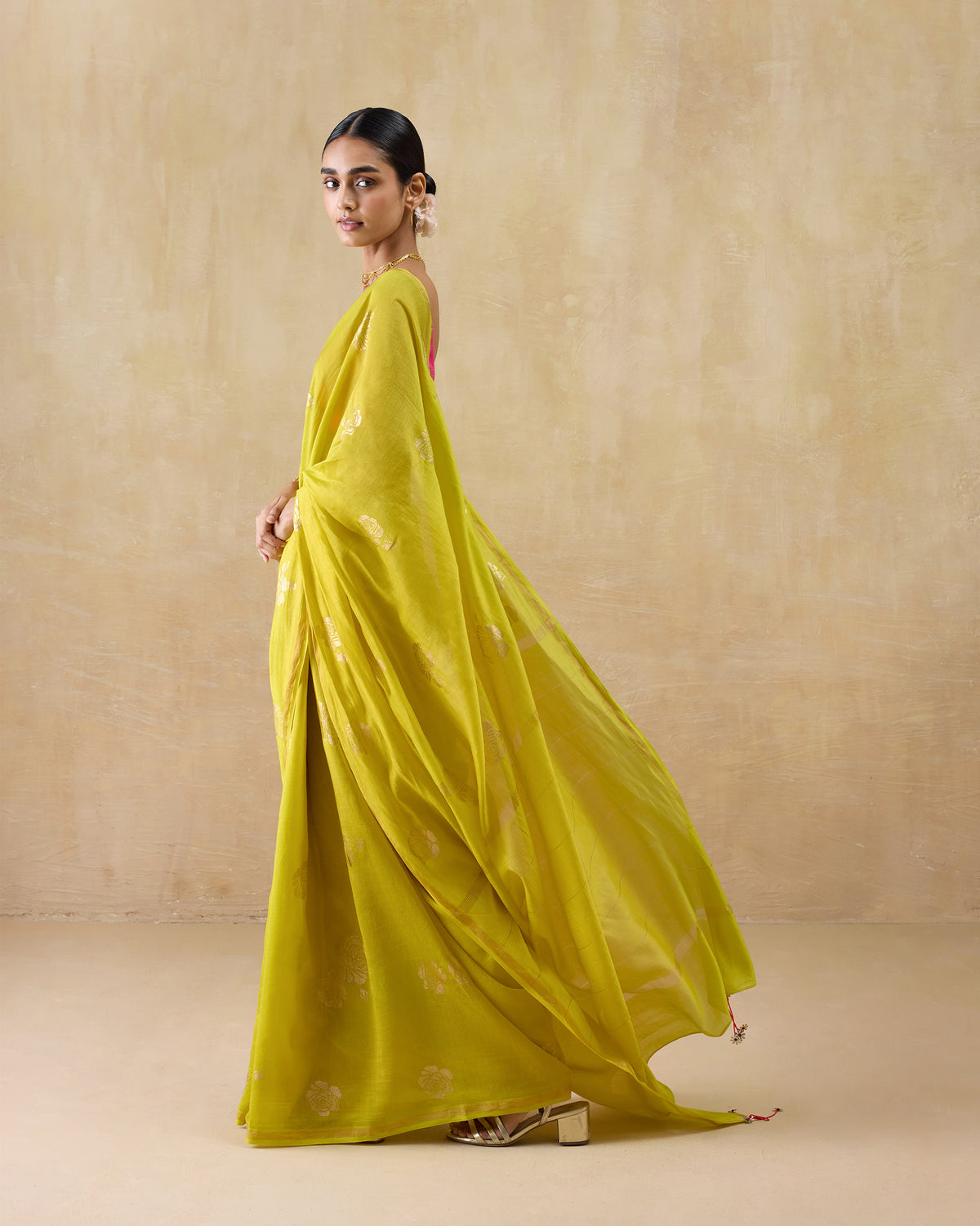 Side profile of a chartreuse Sunset sari with the pallu draped in motion.
