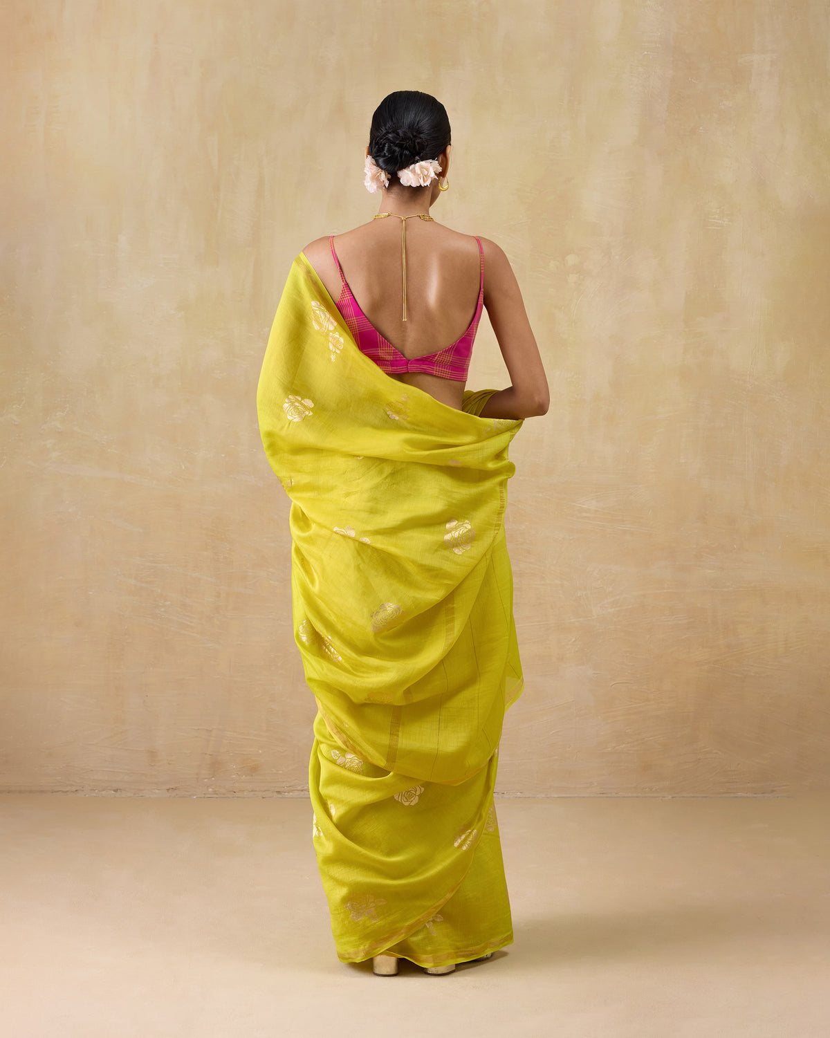 Back of a chartreuse Sunset sari with scattered gold floral motifs.