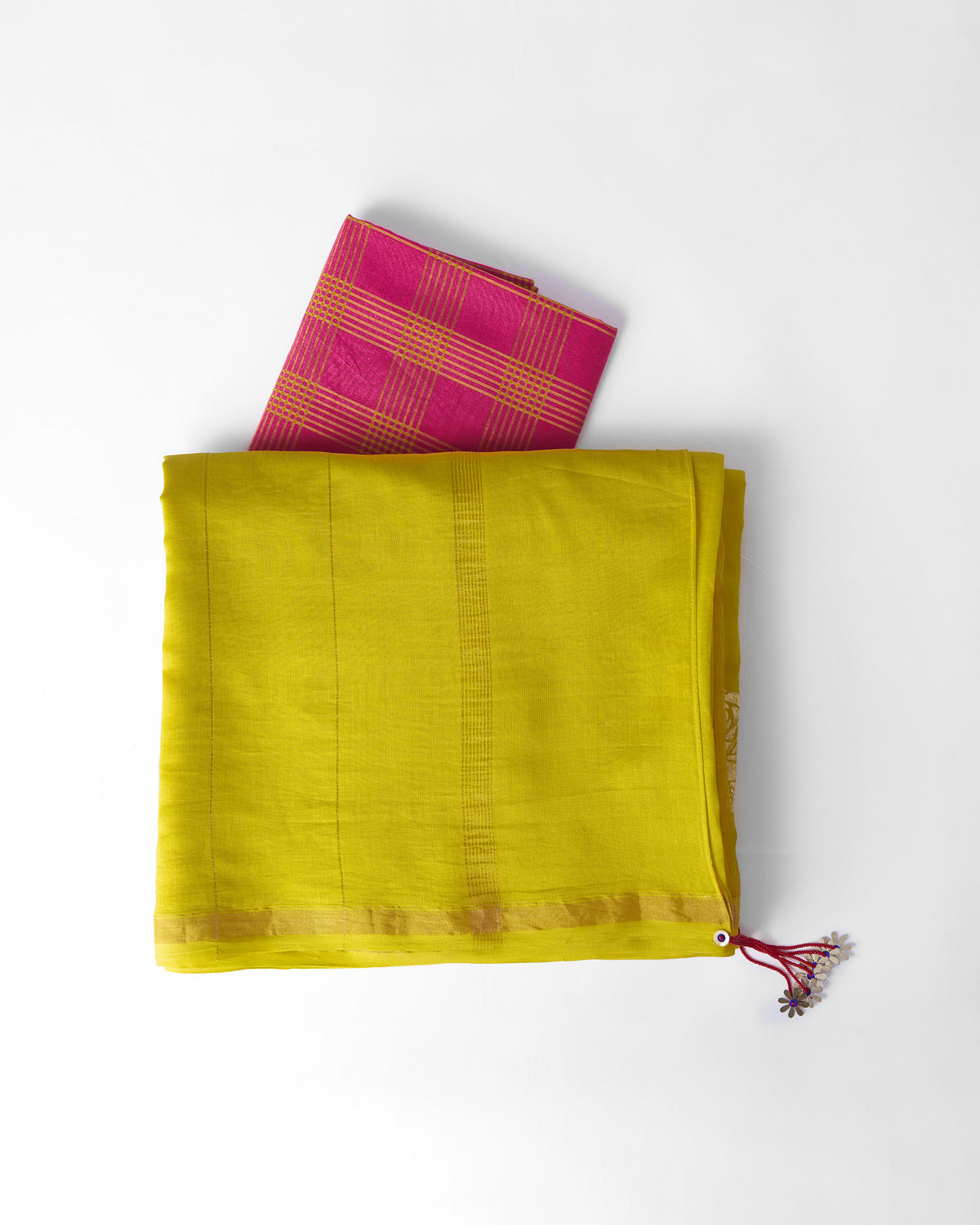 Folded chartreuse Sunset sari with gold border, red tassel and a pink check blouse piece.