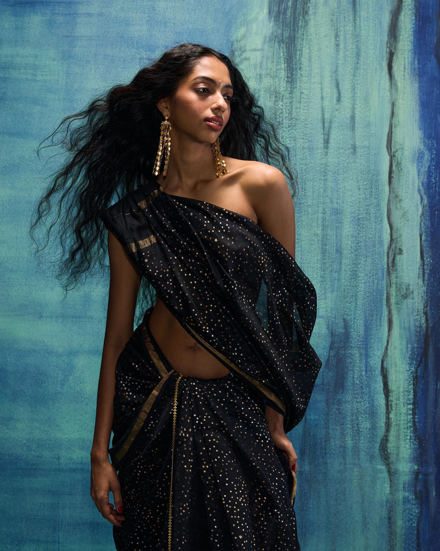 The Riverbank Sari draped off one shoulder against a blue backdrop.