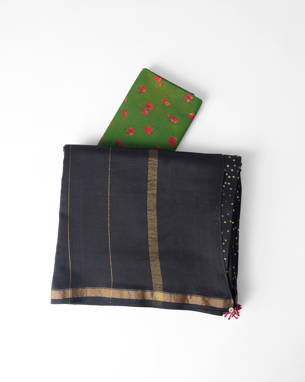 Folded black and gold Riverbank sari with a red tassel and a green floral blouse piece.