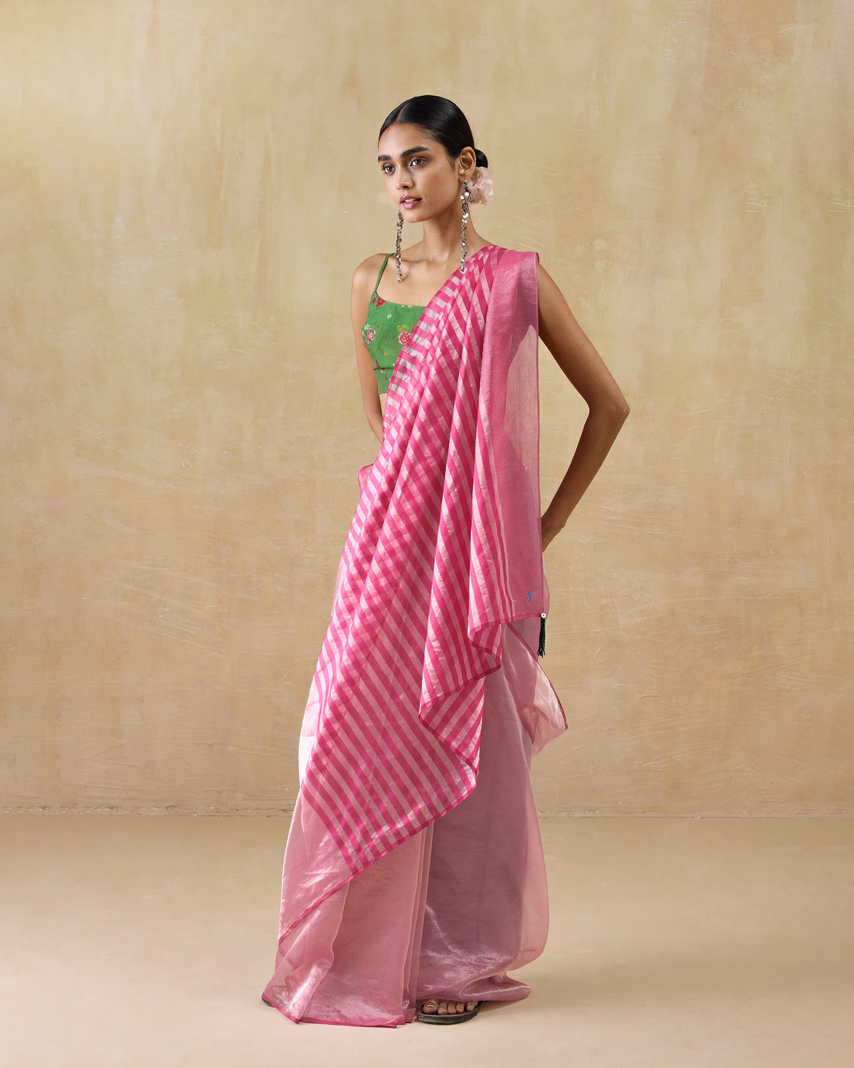 Person wearing a blush pink Blush sari with a sheer striped pallu.